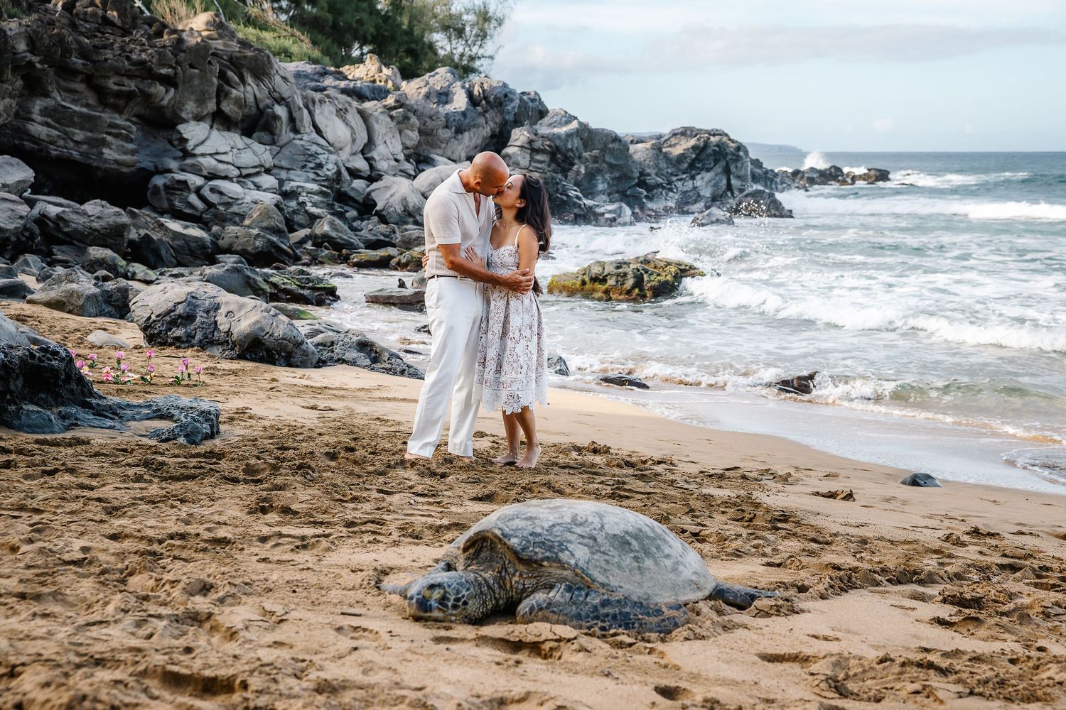 Romantic beach moment with volcanic rocks and crashing waves in Hawaii.