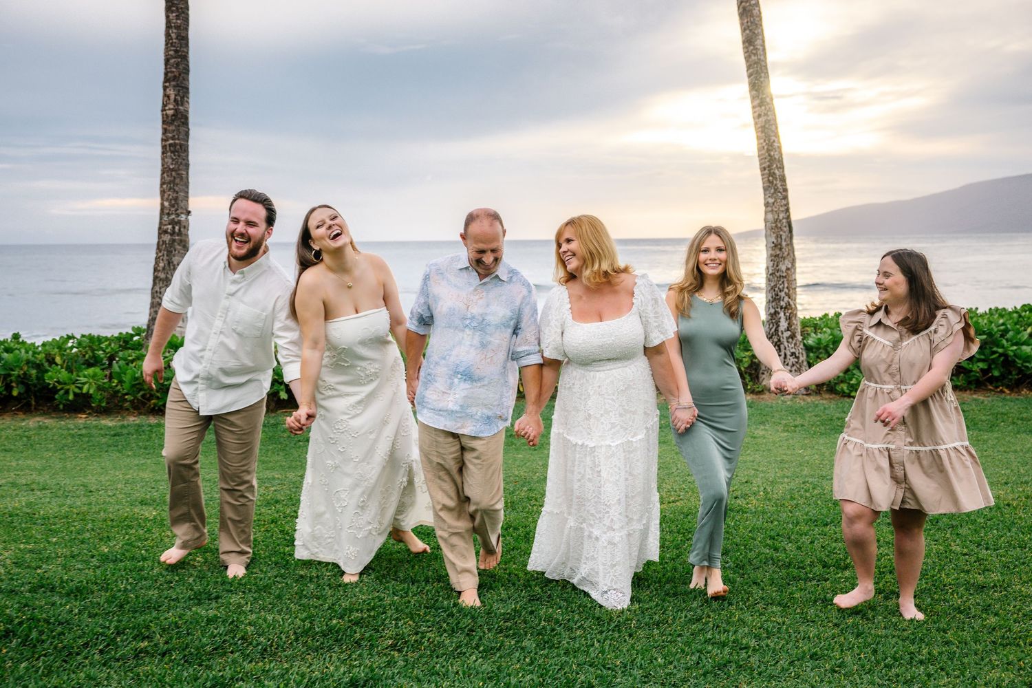 Extended family laughs together during a casual beach photoshoot in Hawaii.
