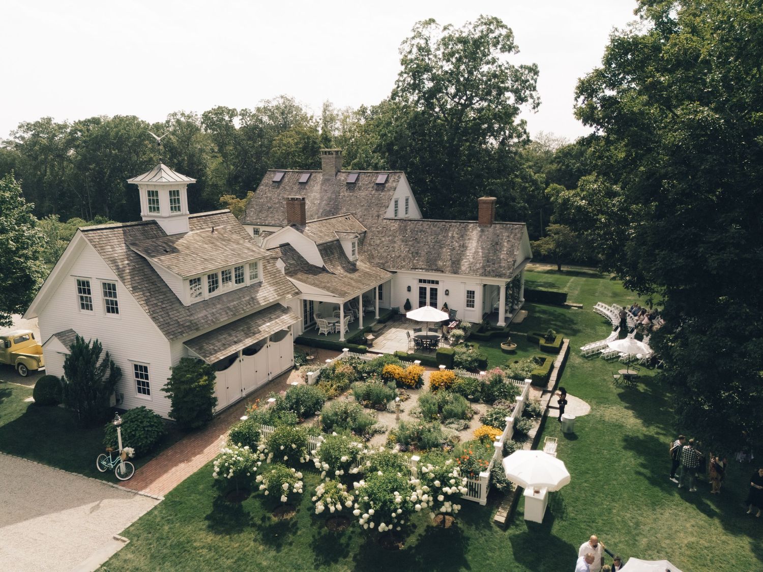 Aerial drone view of residential neighborhood with modern homes and landscaped yards surrounded by trees.
