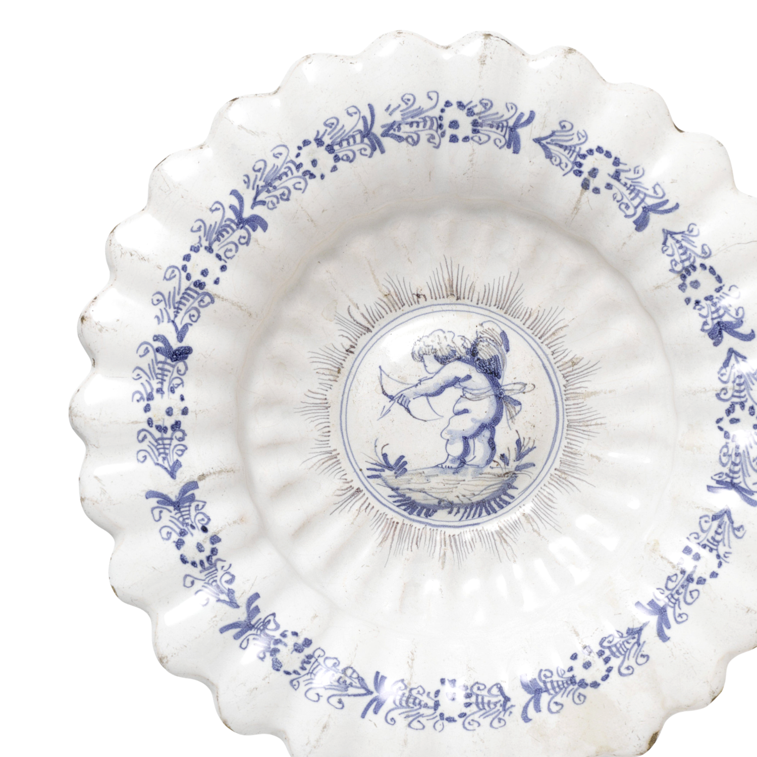 White ceramic plate with blue floral border and cherub center design, scalloped edges, delicate Delft-style porcelain.