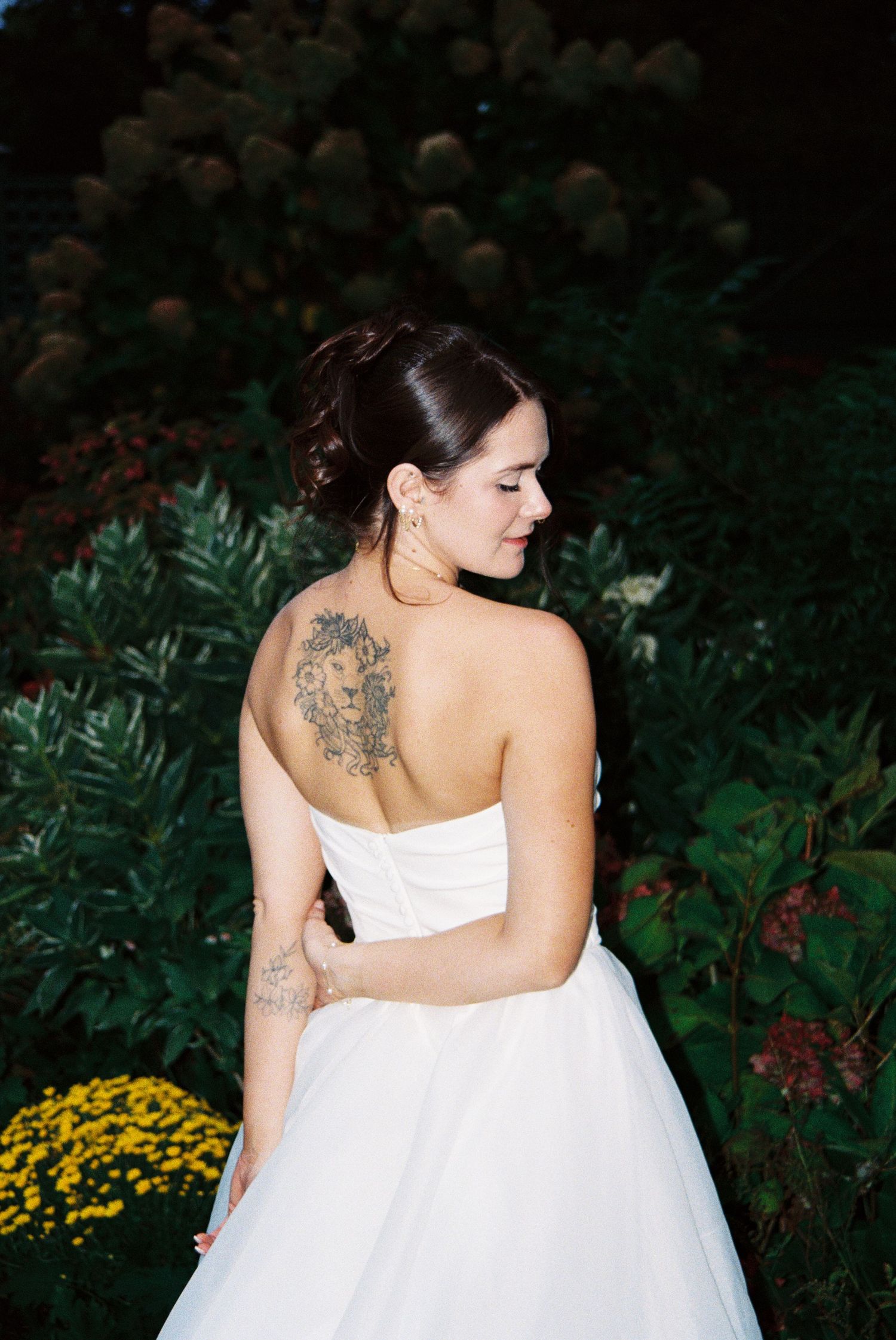 Artistic bridal portraits showing intricate back tattoo details through white wedding dress.
