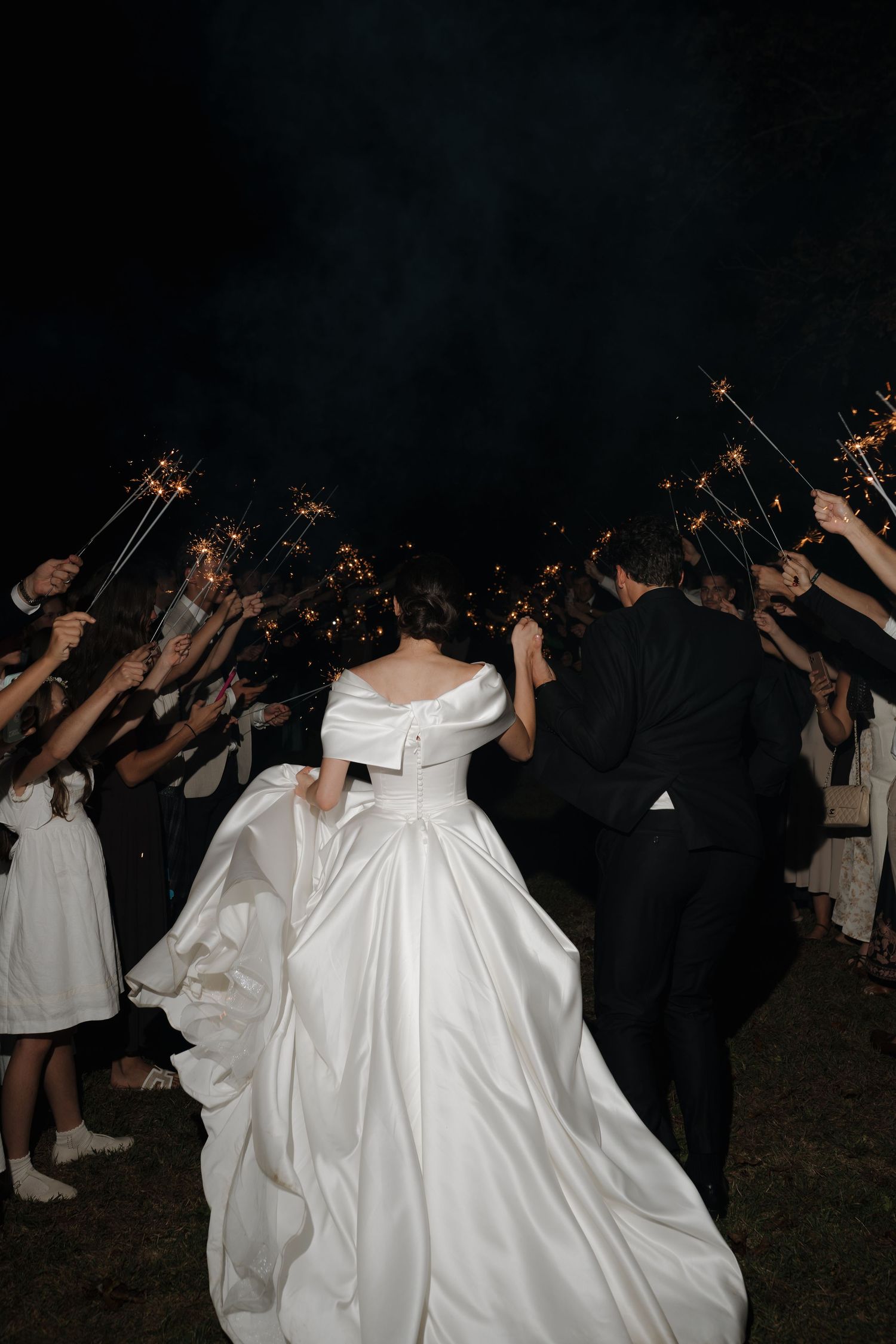 Wedding celebration at night with sparklers creating a magical glow.
