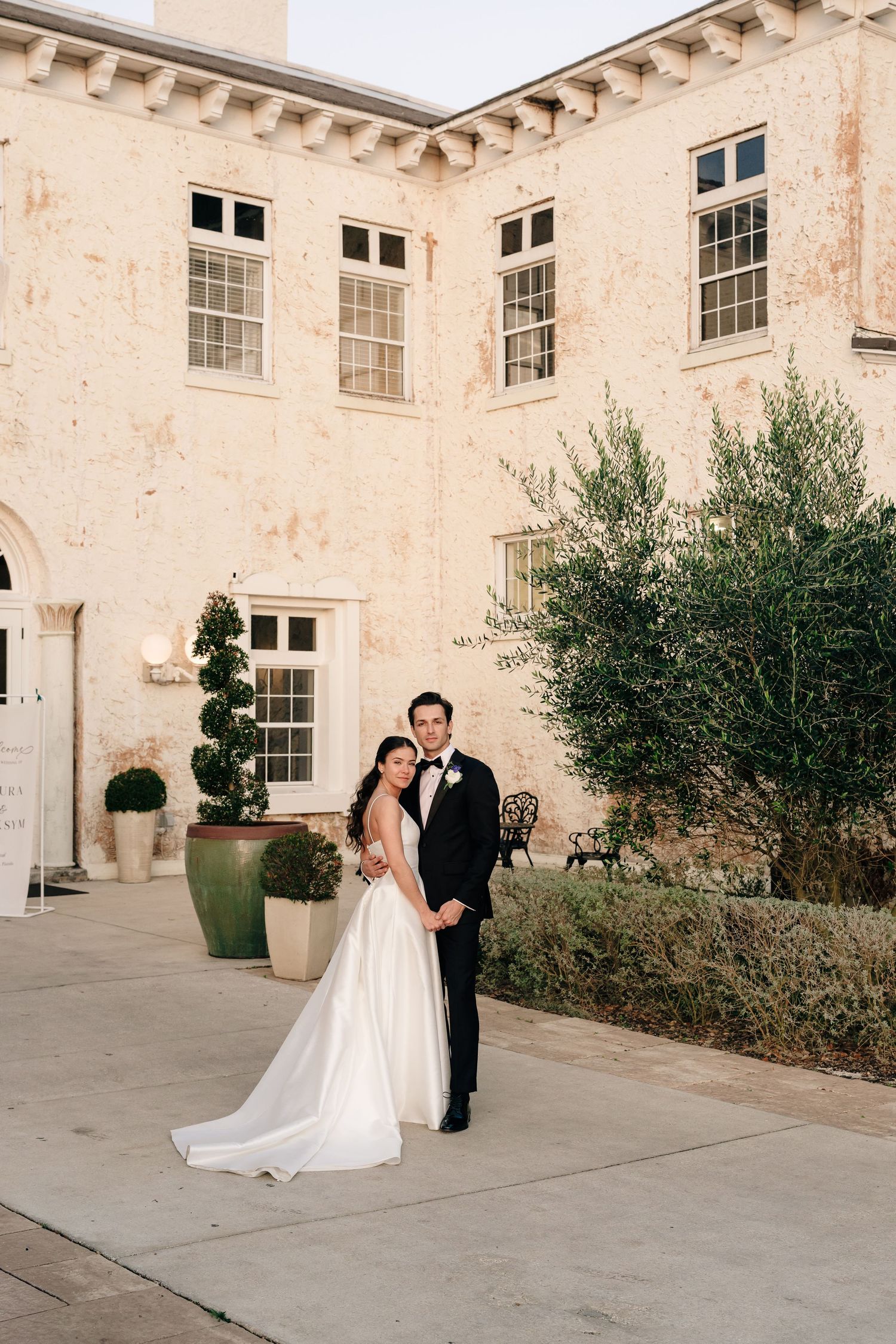 Wedding photo sequence showing couple posing in front of historic stone building with arched windows.