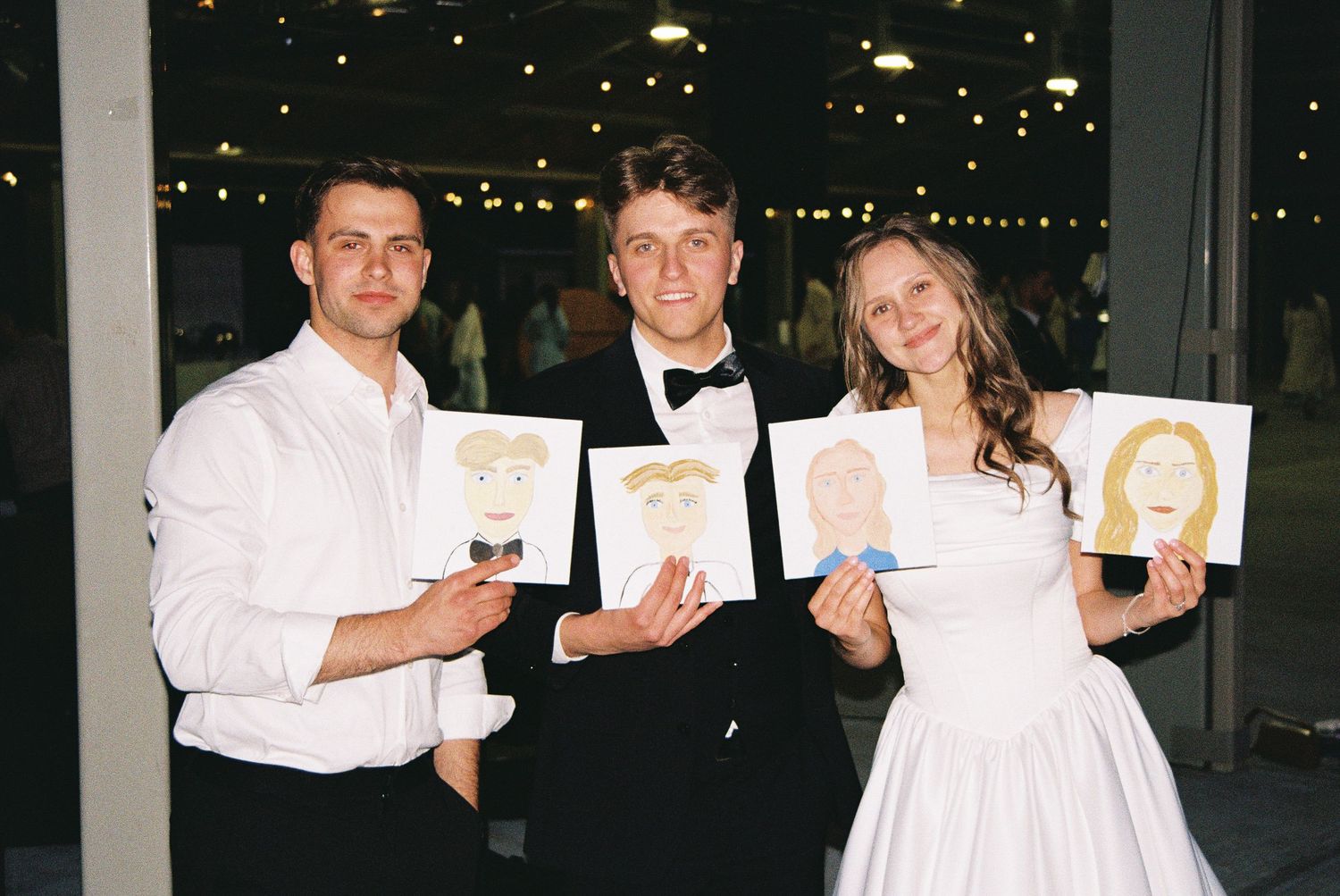 A group of people in white formal attire hold up drinks for a toast at an evening celebration.