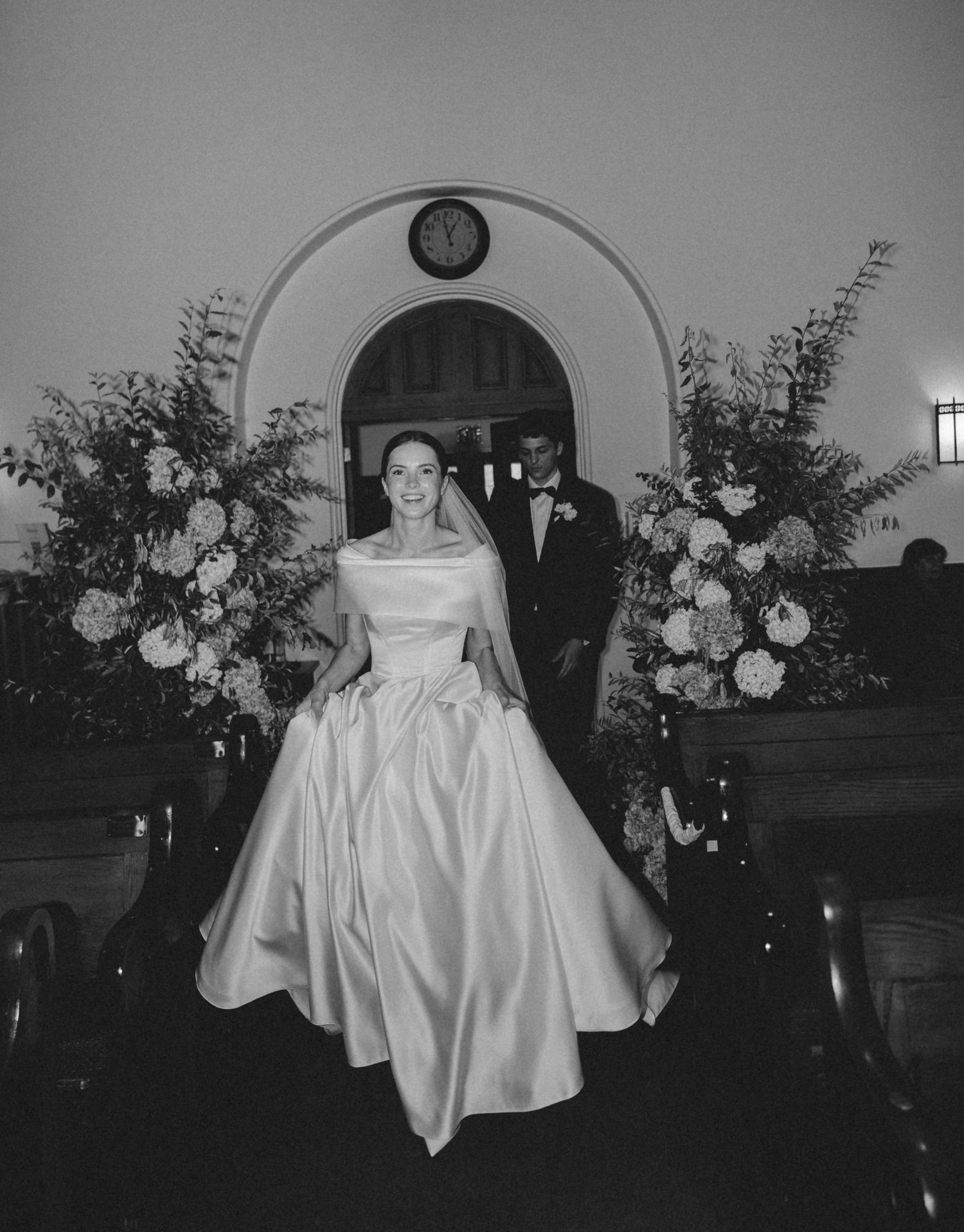 A series of black and white wedding photographs showing a couple during their ceremony with floral arrangements.