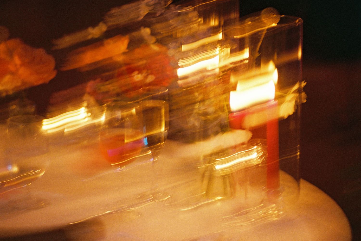 Abstract motion blur of glowing amber and gold light refracting through glass blocks on a white surface.