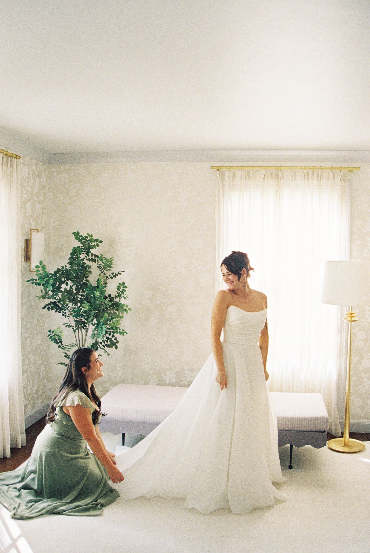 Light-filled room with white walls showing wedding dress preparations.