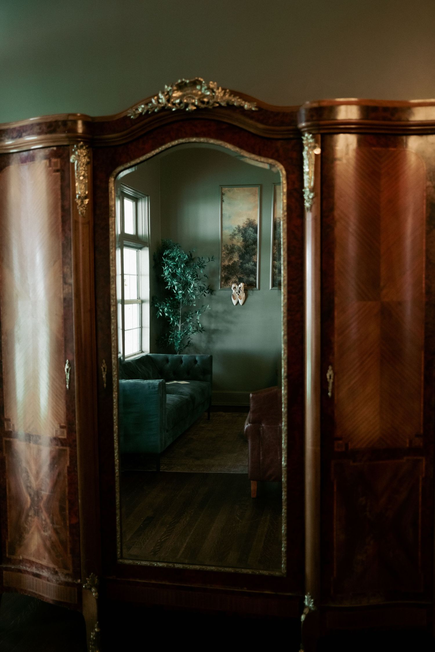 Dark wood-paneled interior hallway with ornate mirrors and moldings in an abandoned mansion creates a moody atmosphere.