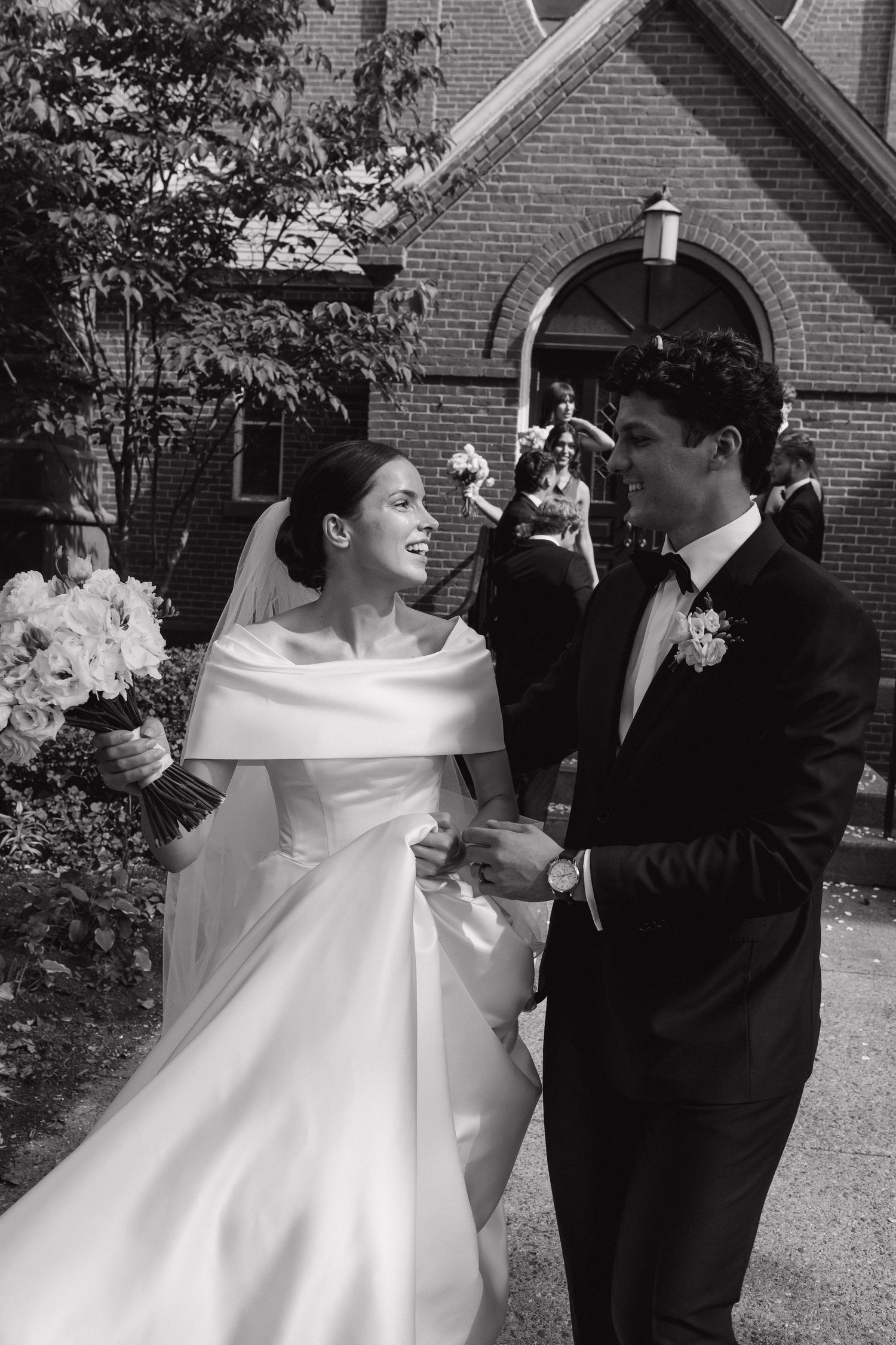 Black and white wedding portrait series outside a brick church.