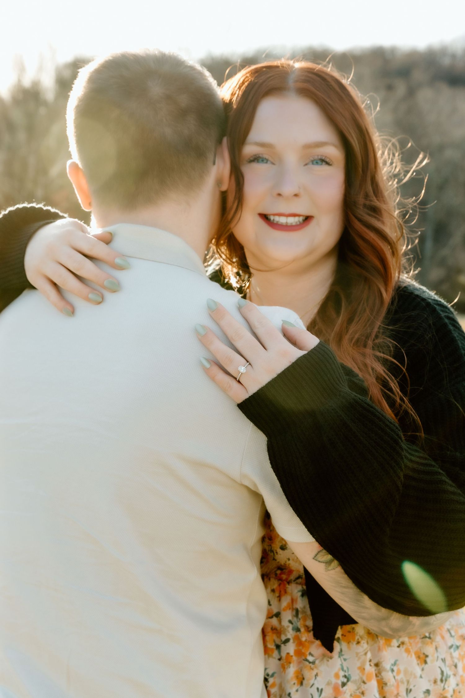 Close up engagement photos of couple embracing outside during golden hour in a romantic autumn setting.