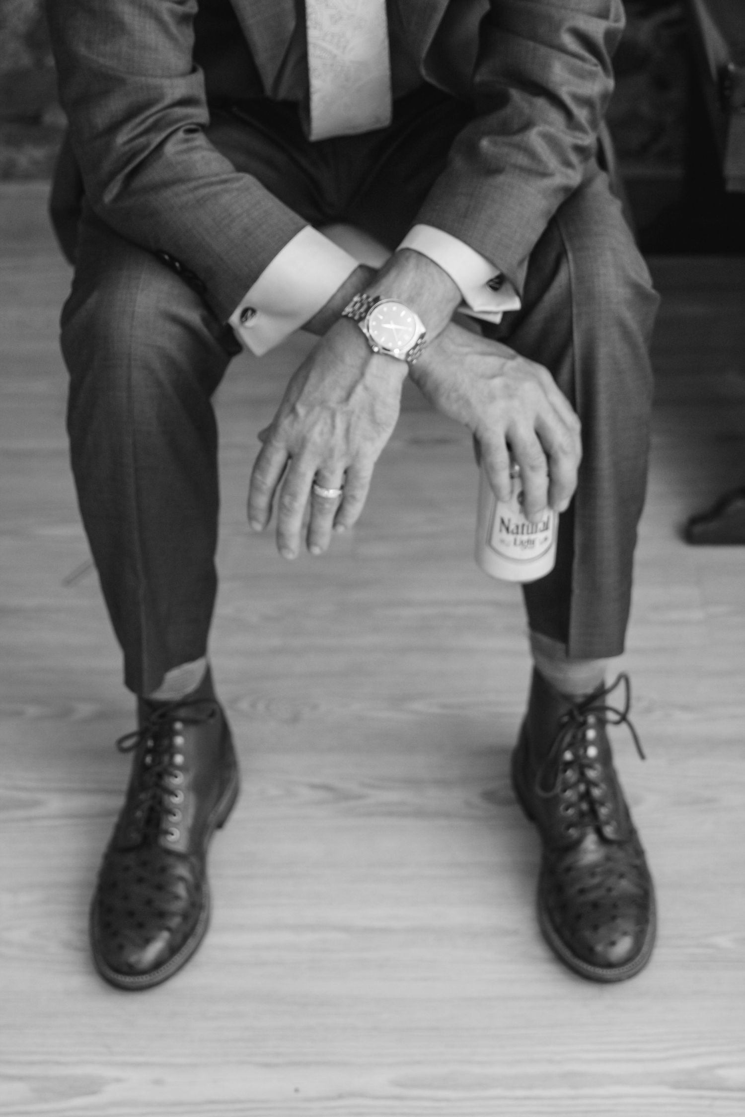 Black and white detail shots of groomsmen's dress shoes and pants while sitting.