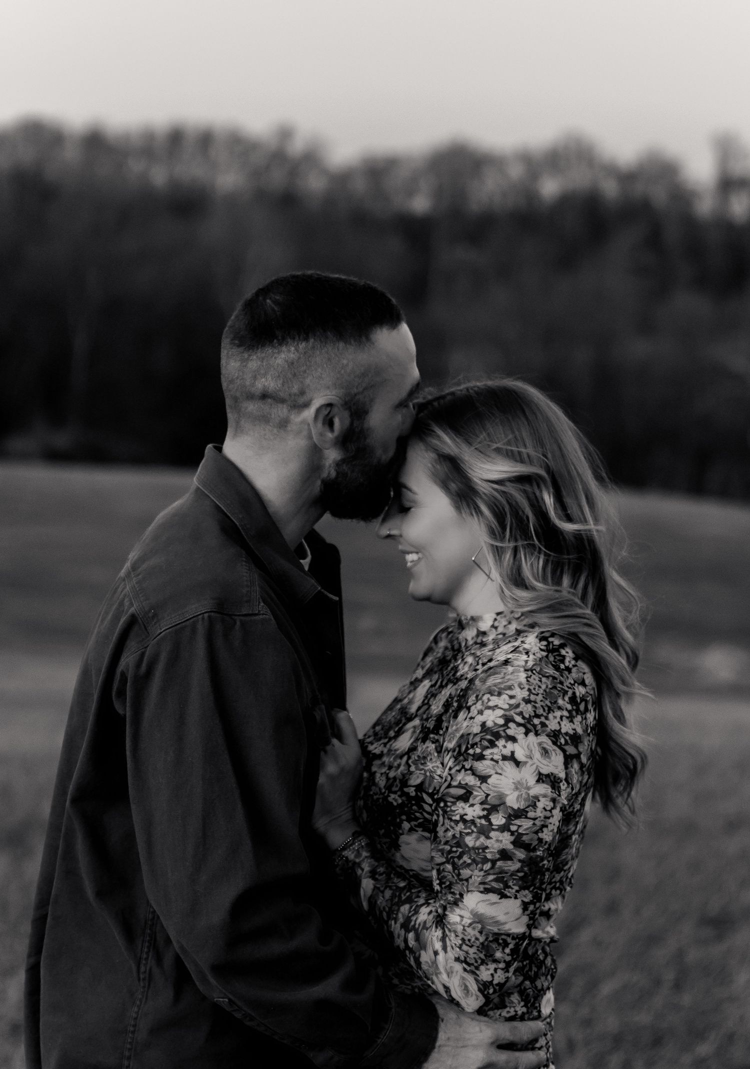 A romantic black and white photo series showing a couple embracing in various intimate poses outdoors in a field. Harford County