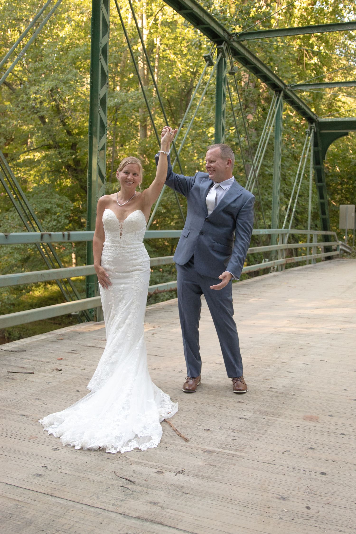 Playful wedding photo sequence showing couple dancing on a wooden bridge surrounded by green trees.
