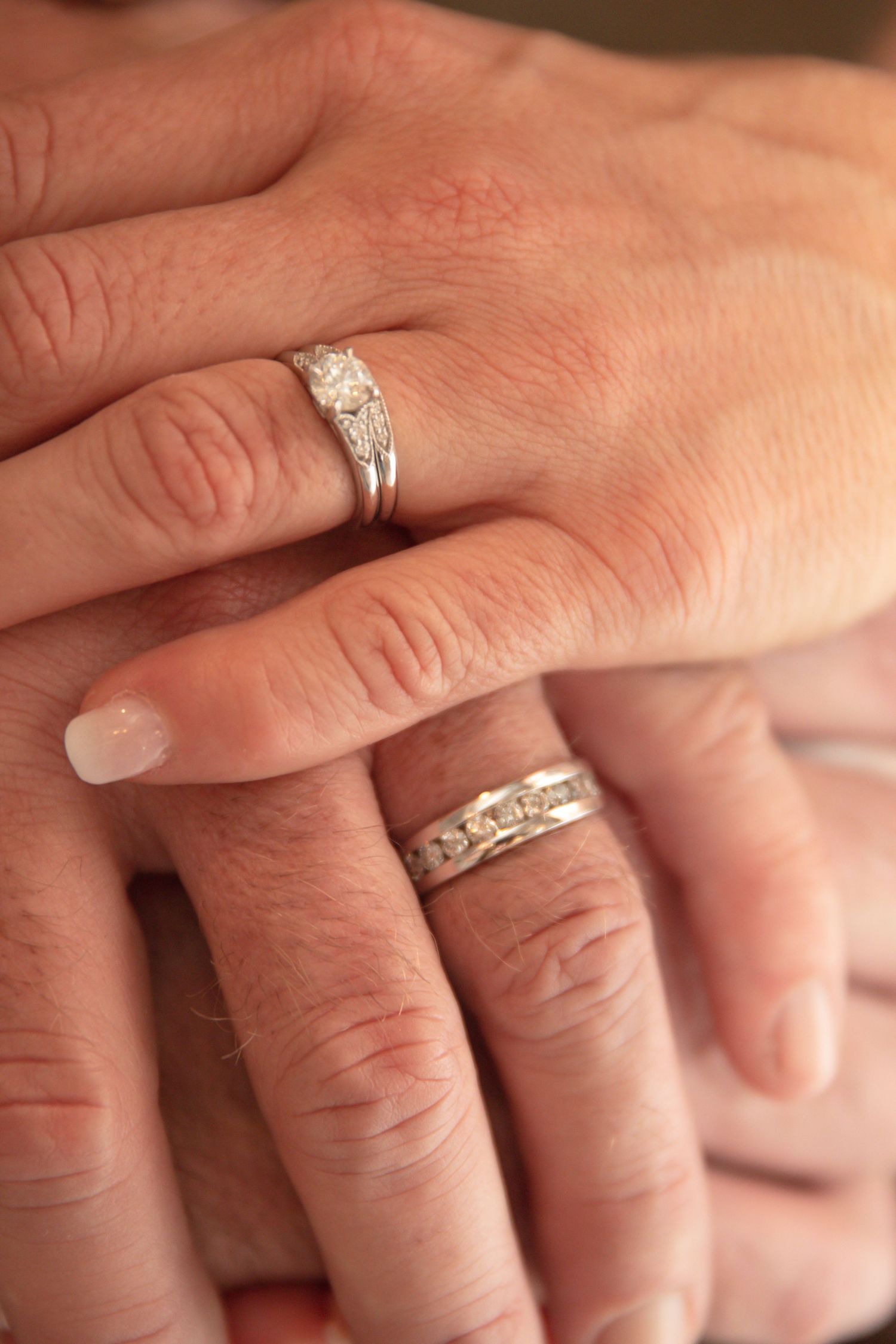 Close-up detail shots of diamond engagement and wedding rings on hands in various angles.