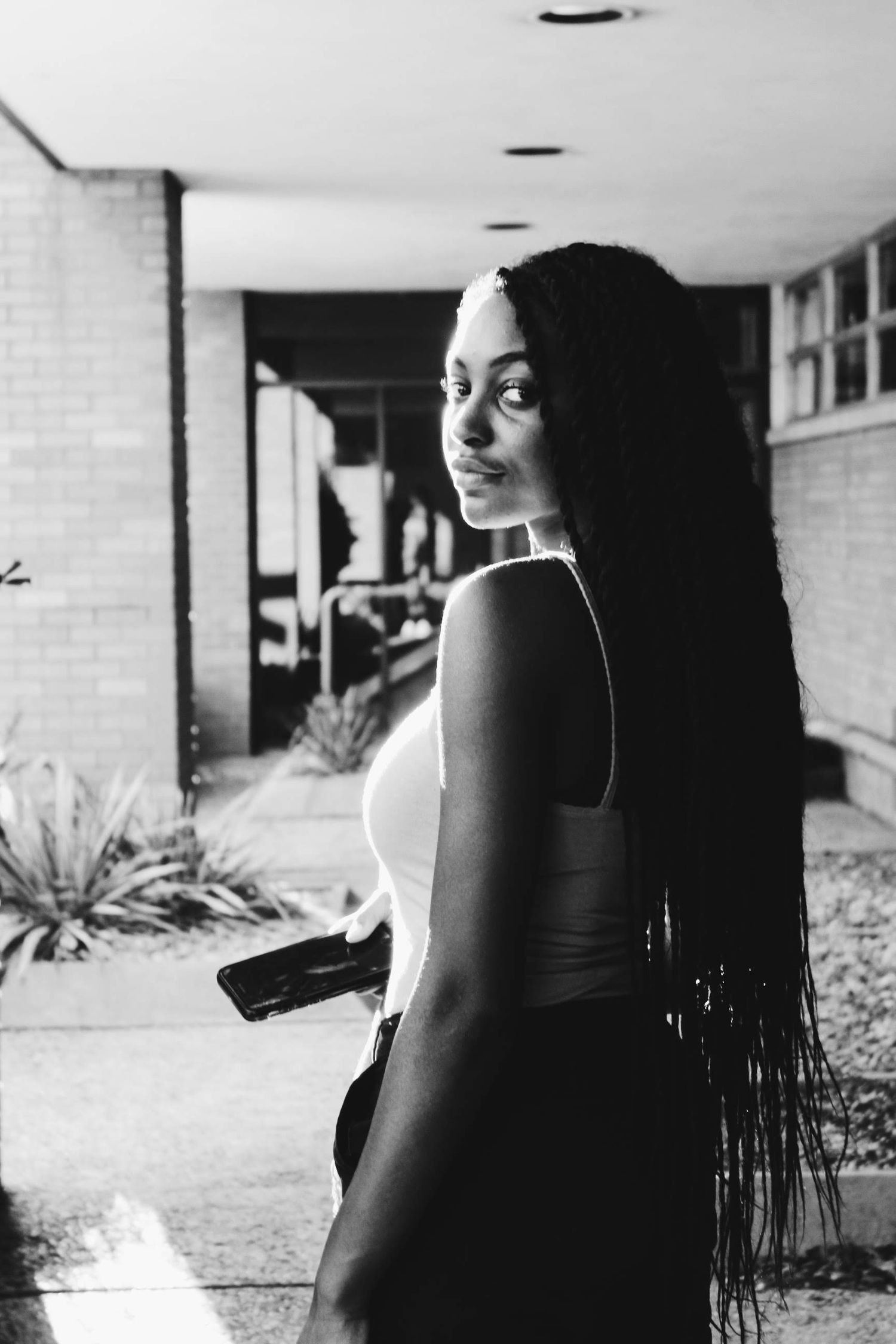 Black-and-white photo of a model looking back over her shoulder, with light hitting her from behind