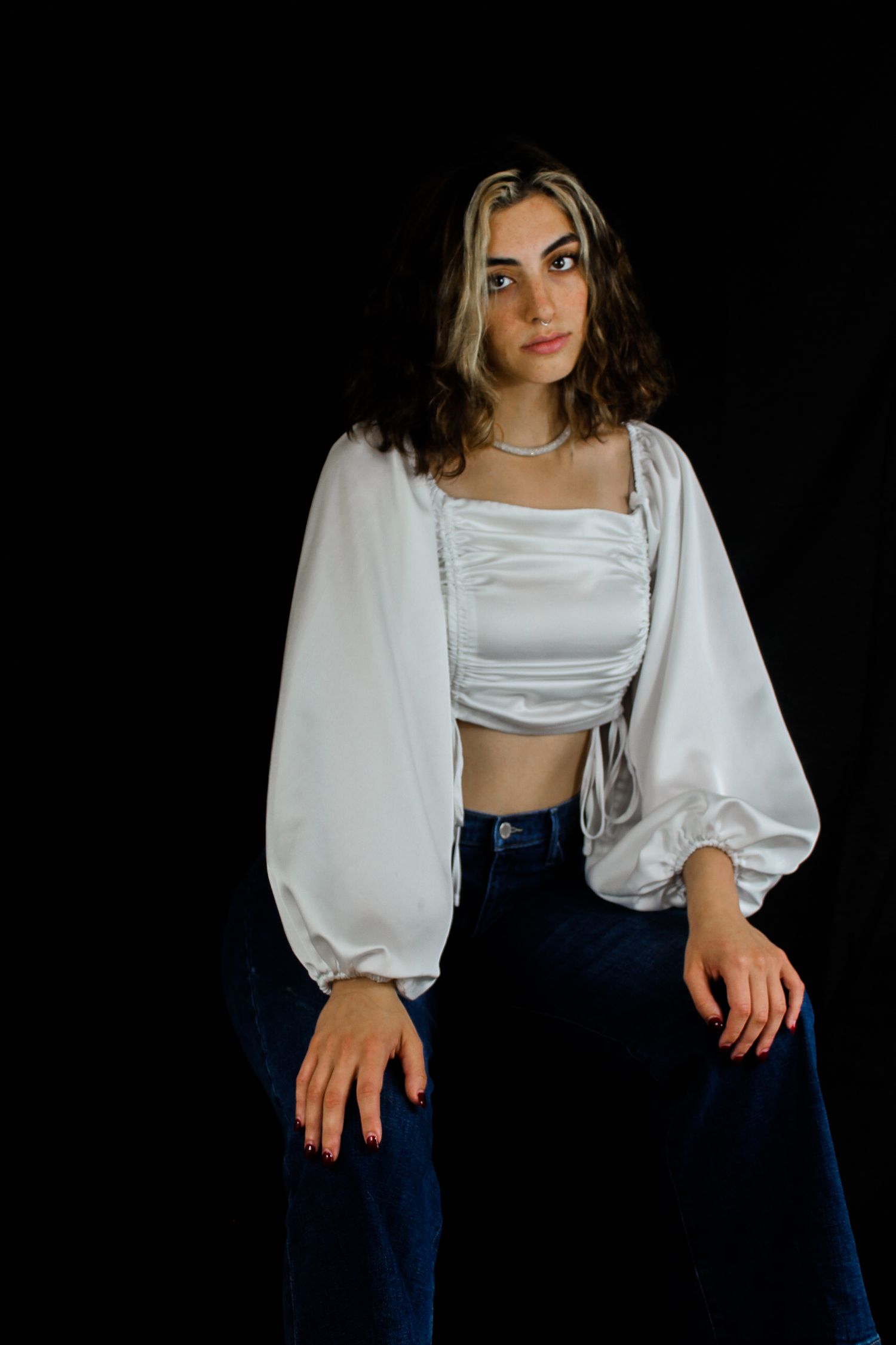 Model posing with a serious expression against a black background.