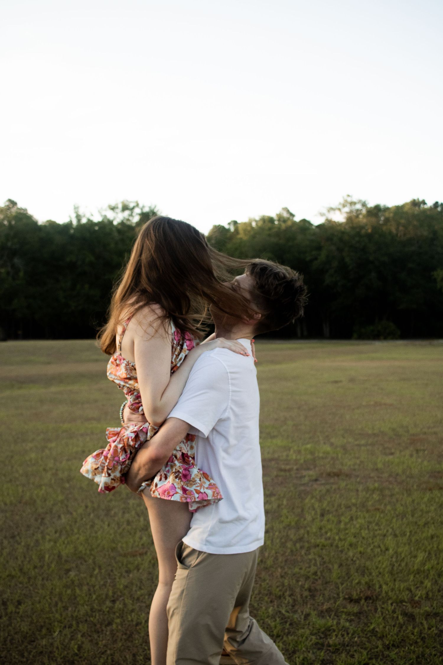 Couple captured in a dreamy, blurry moment as the boyfriend lifts his girlfriend and swings her around.