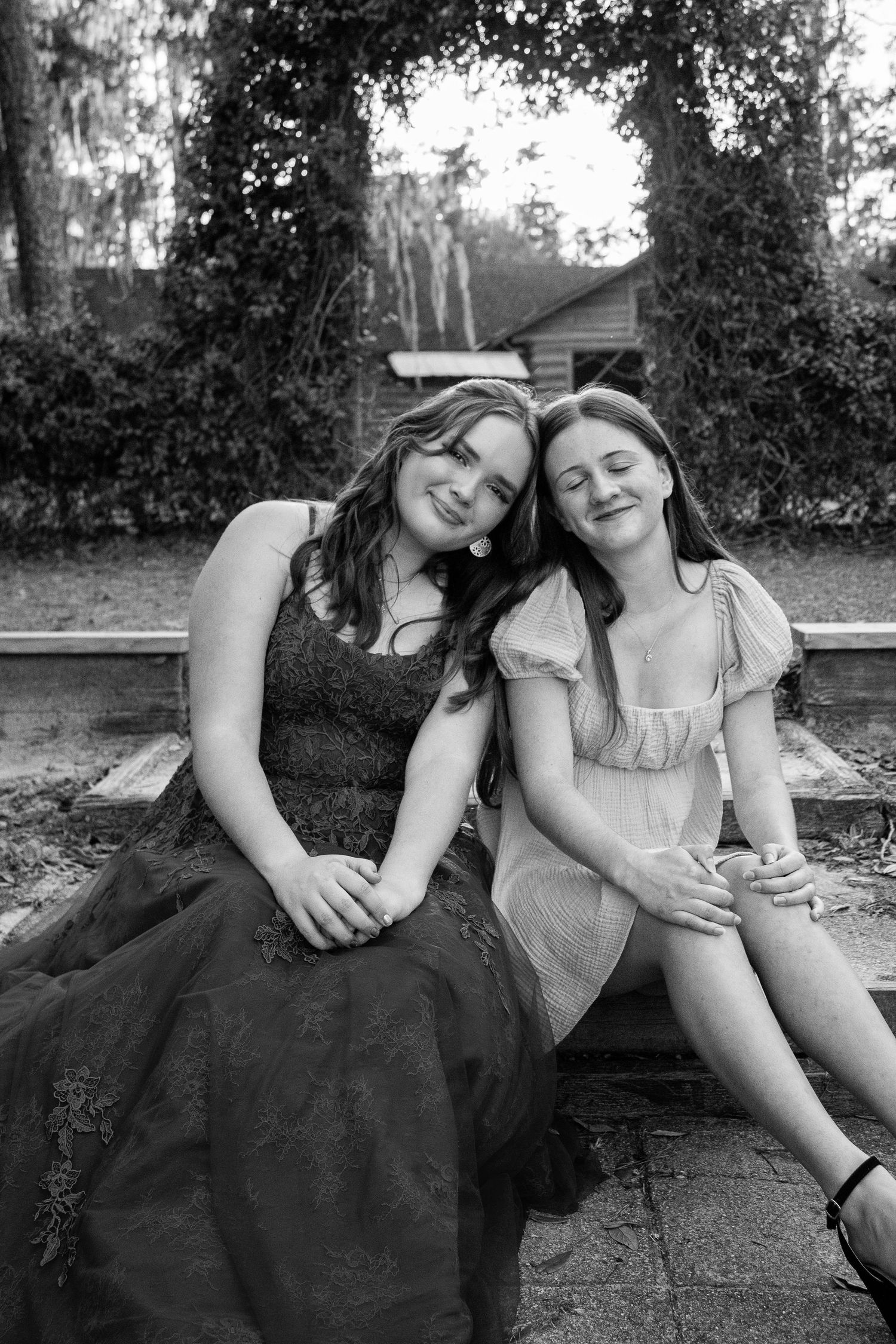 Two best friends at a Sweet 16 birthday celebration, leaning on each other and sharing a joyful moment.