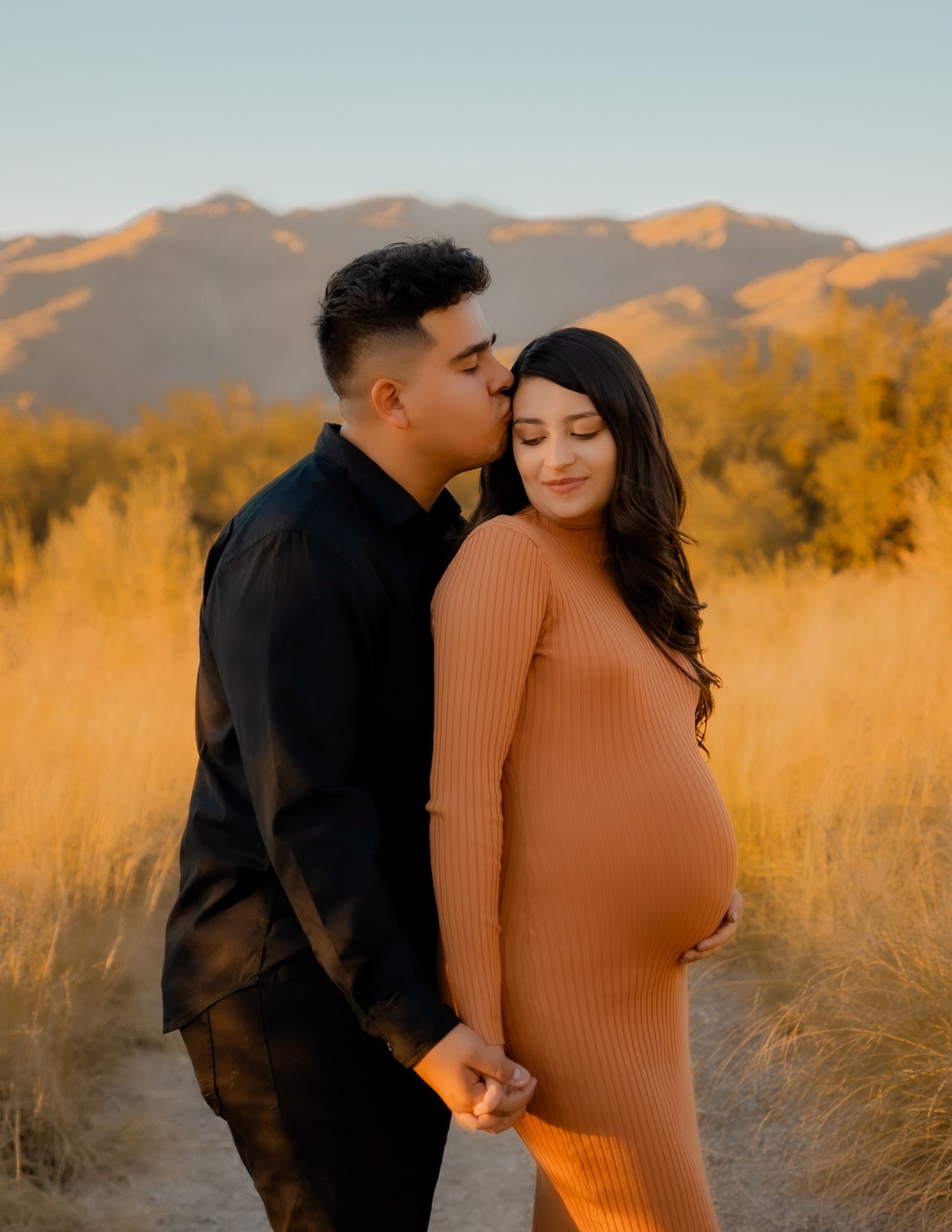 Joyful mother-to-be posing in a flowing dress during maternity session