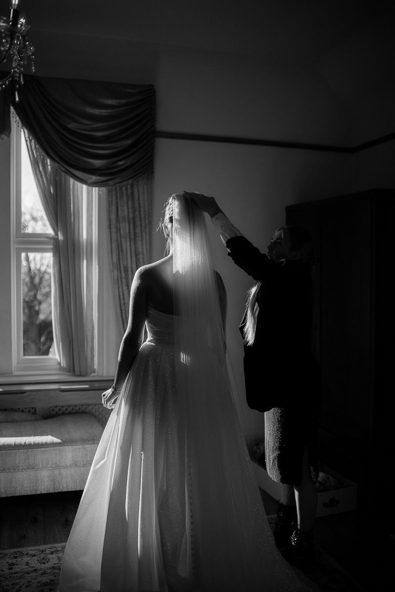 Dramatic black and white sequence showing a figure in a flowing white dress being photographed near a window.