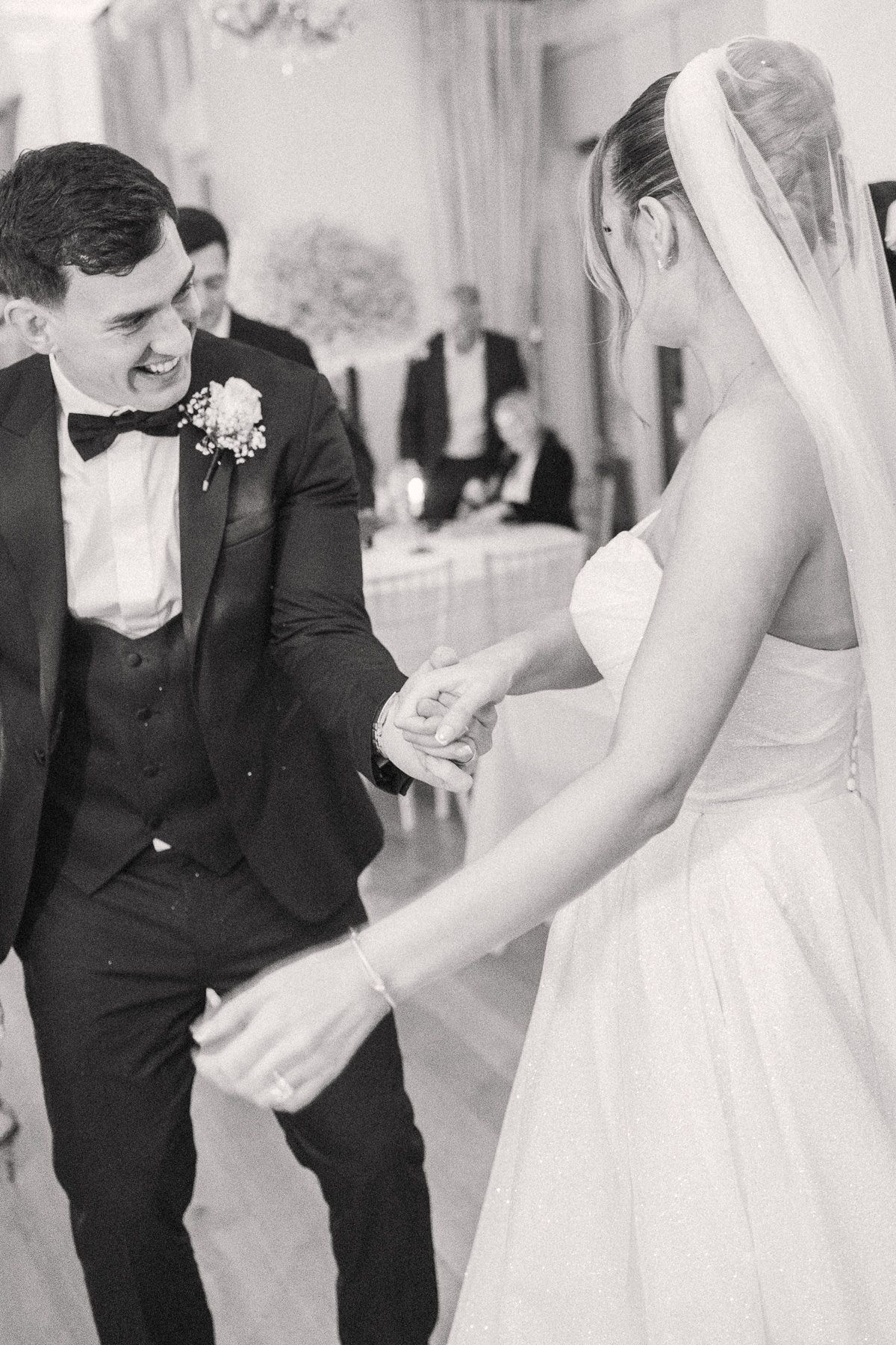 A bride and groom are holding hands and gazing at each other during their wedding ceremony.