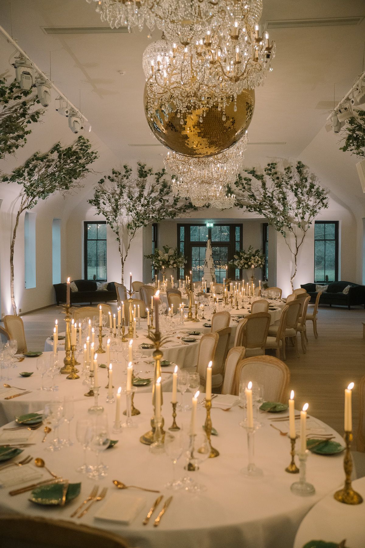 A luxurious dining room with a grand crystal chandelier, candle-lit tables, and lush floral arrangements.