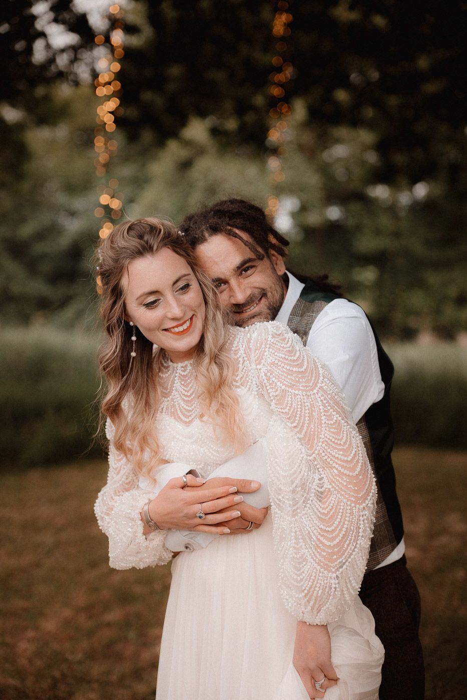A romantic outdoor autumn wedding portrait with couple embracing in a natural setting.