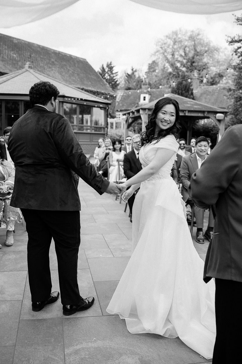 Black and white wedding reception photo sequence showing guests dancing and mingling on an outdoor patio.