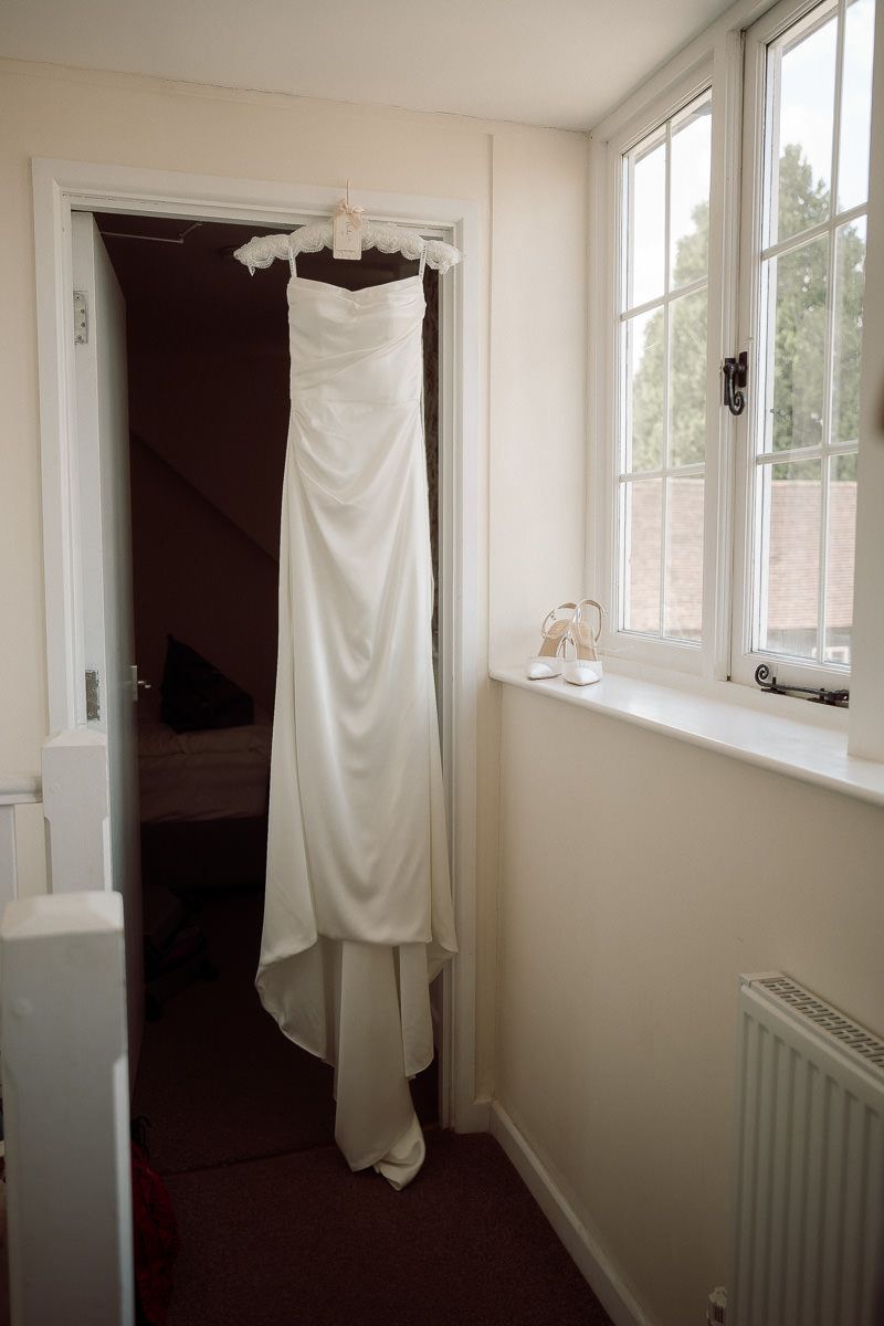 White curtains or fabric panels hanging in a bright room with windows and white walls, creating a minimalist interior space.