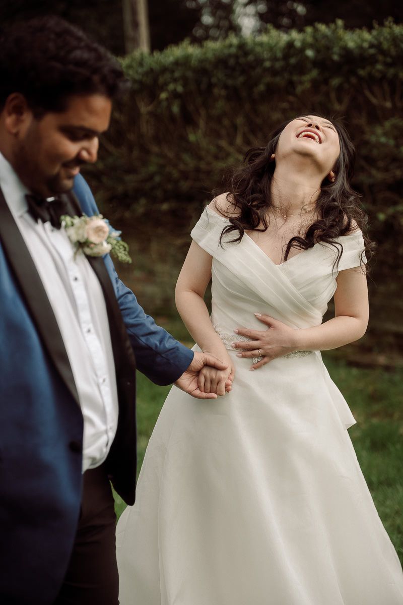 A couple shares a joyful moment while dancing together at their wedding celebration outdoors.