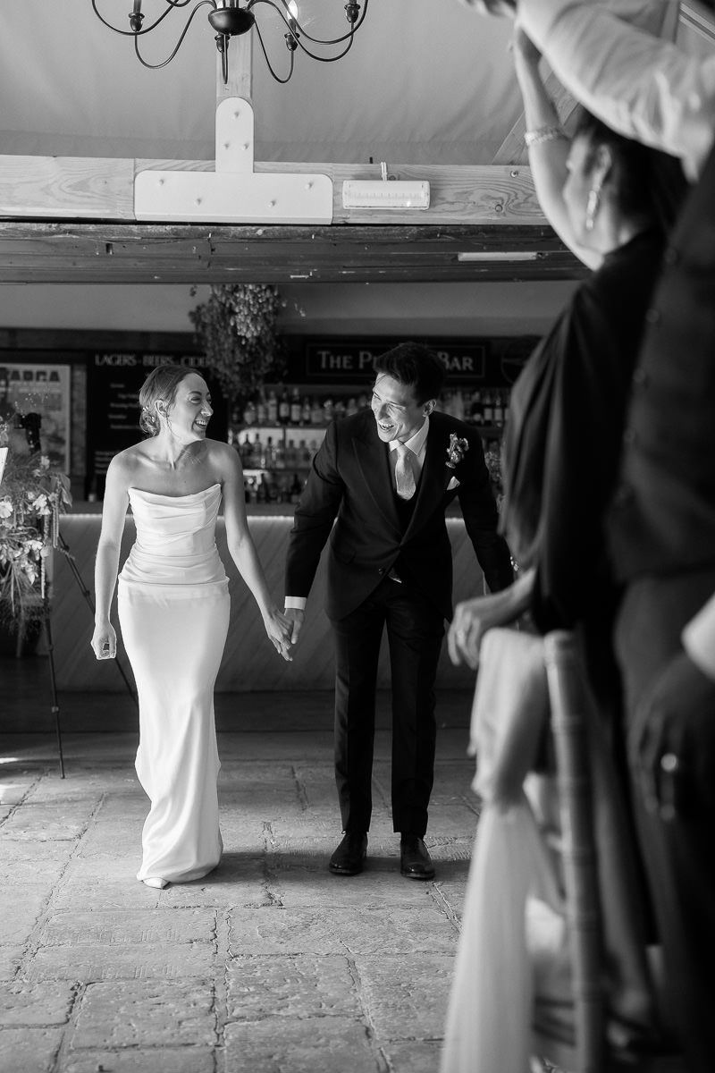 A black and white sequence of wedding photos showing dancing and celebration on a rustic stone floor.
