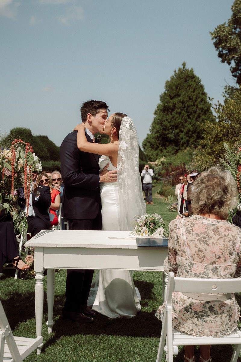 A romantic outdoor wedding sequence shows a couple sharing a kiss at a white table with floral decorations.