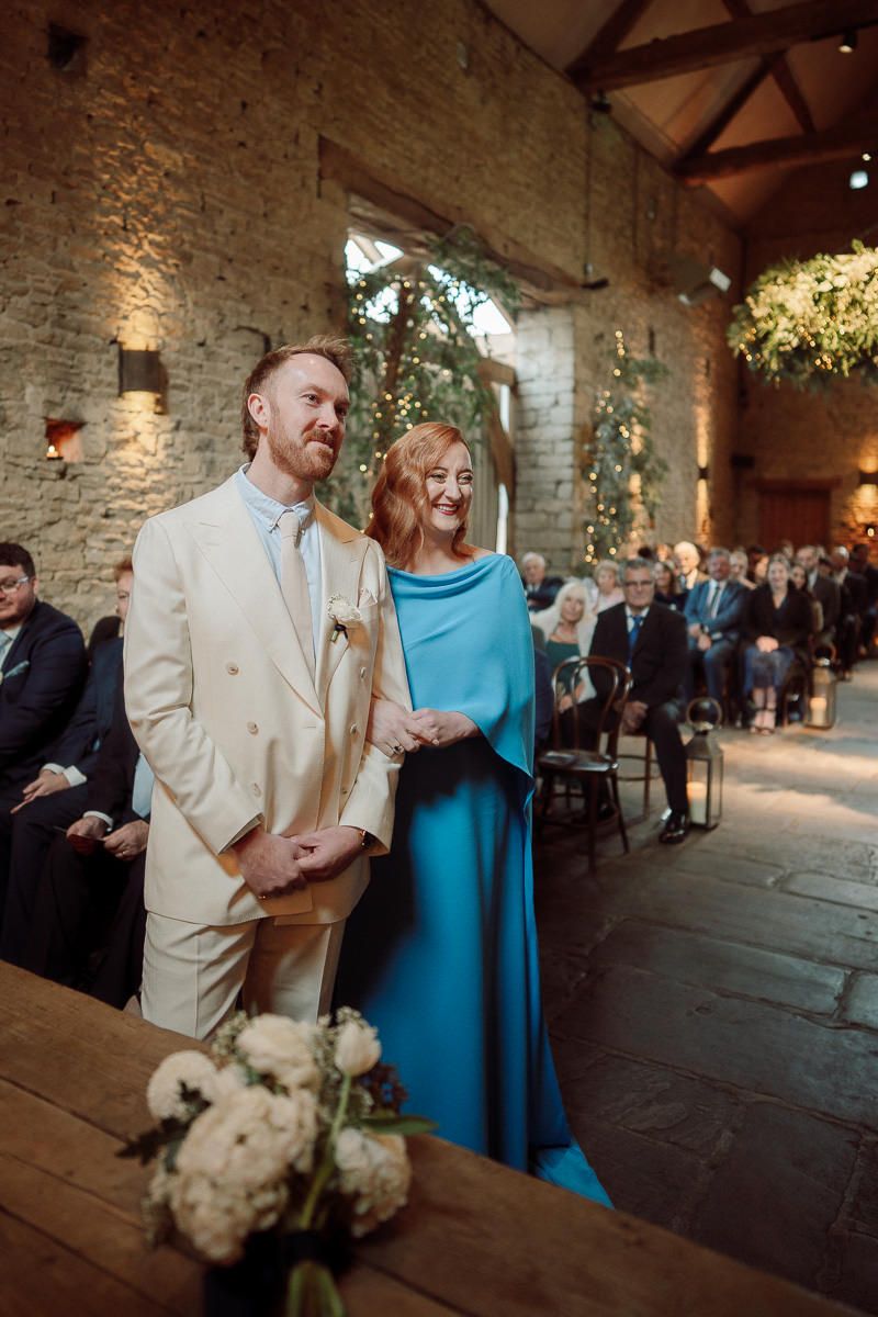 Wedding reception in a rustic stone venue with guests mingling and celebrating in an atmospheric setting.