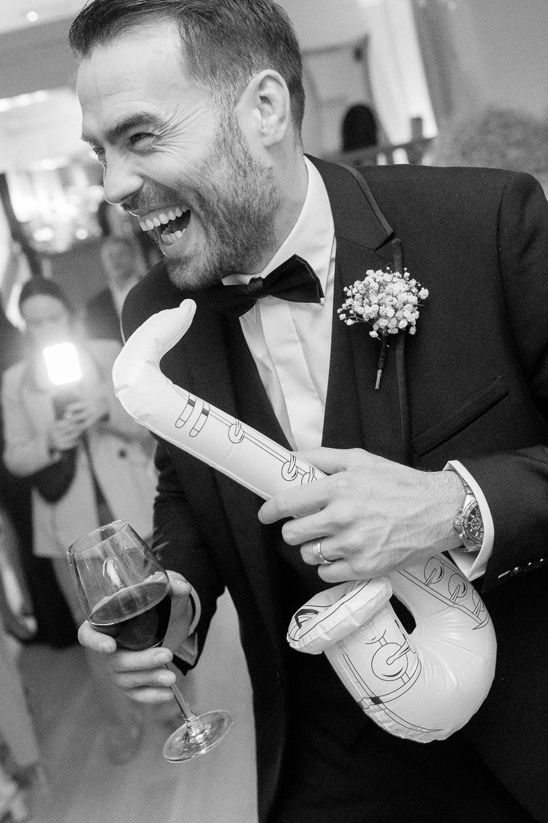 Black and white photo sequence showing person in tuxedo laughing while holding a champagne bottle.