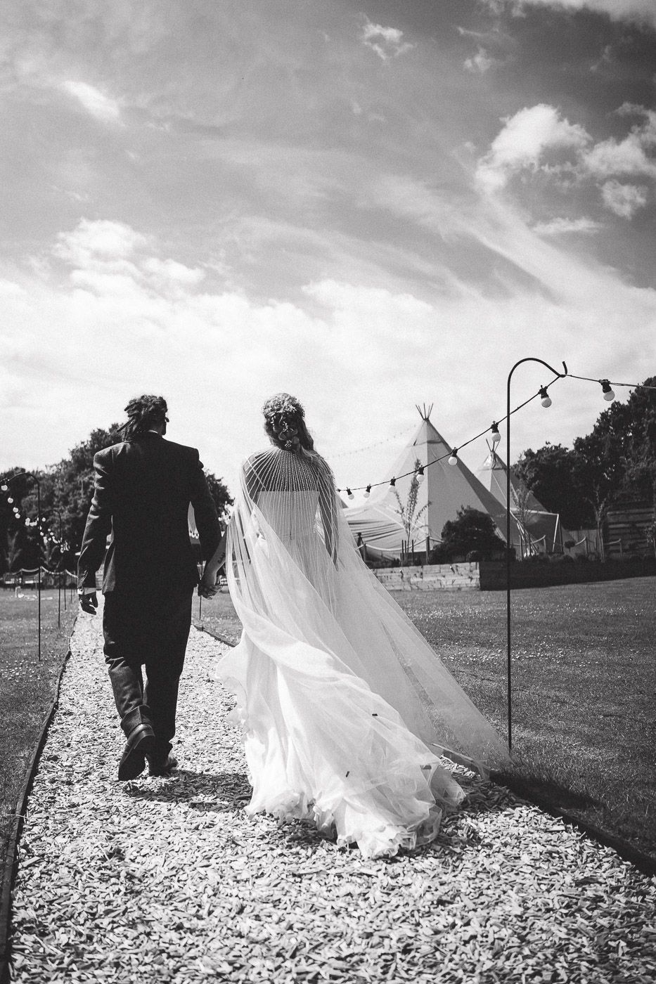Artistic wedding photo sequence showing couple walking through fluttering white fabric panels in an outdoor setting.