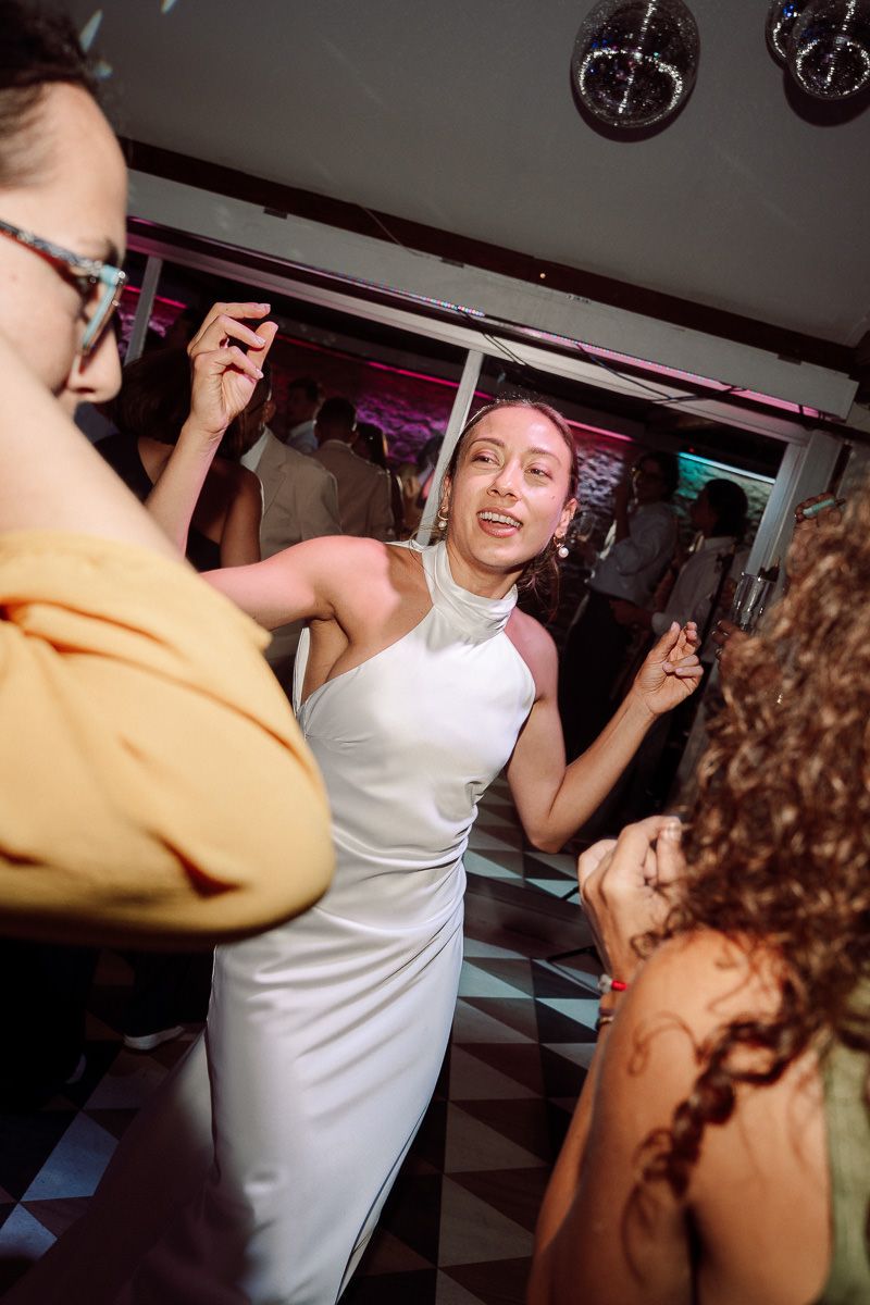 People dancing and having fun at a party in a room with black and white checkered floors.