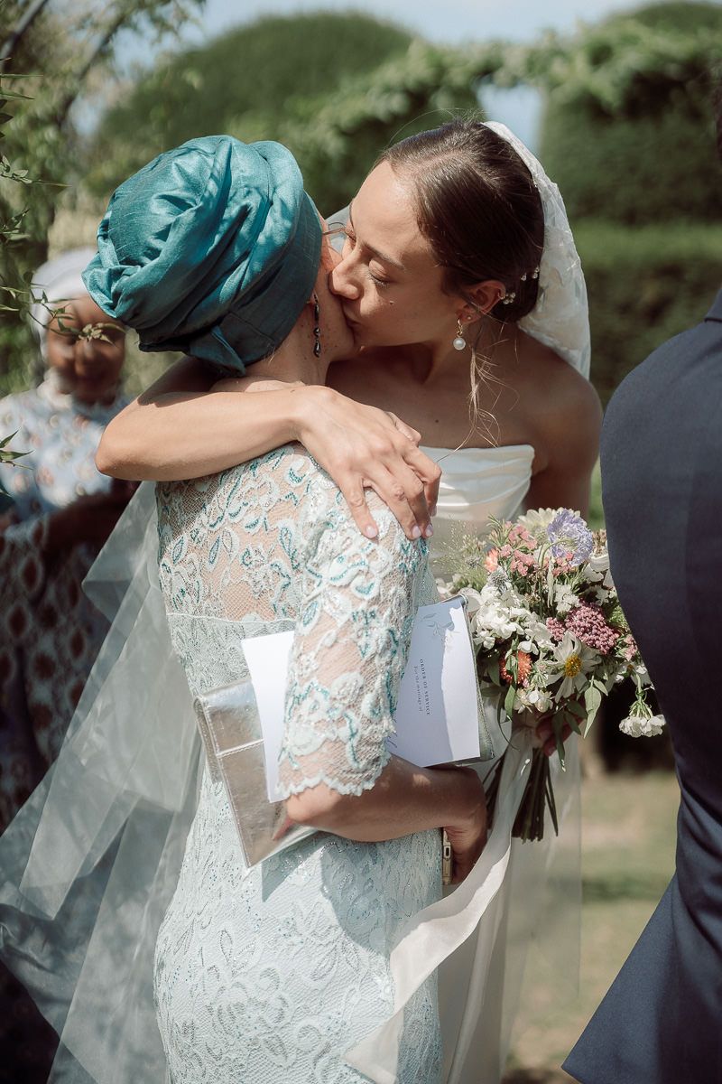 Wedding couple shares intimate moments in a garden setting with delicate lace details and floral bouquet.
