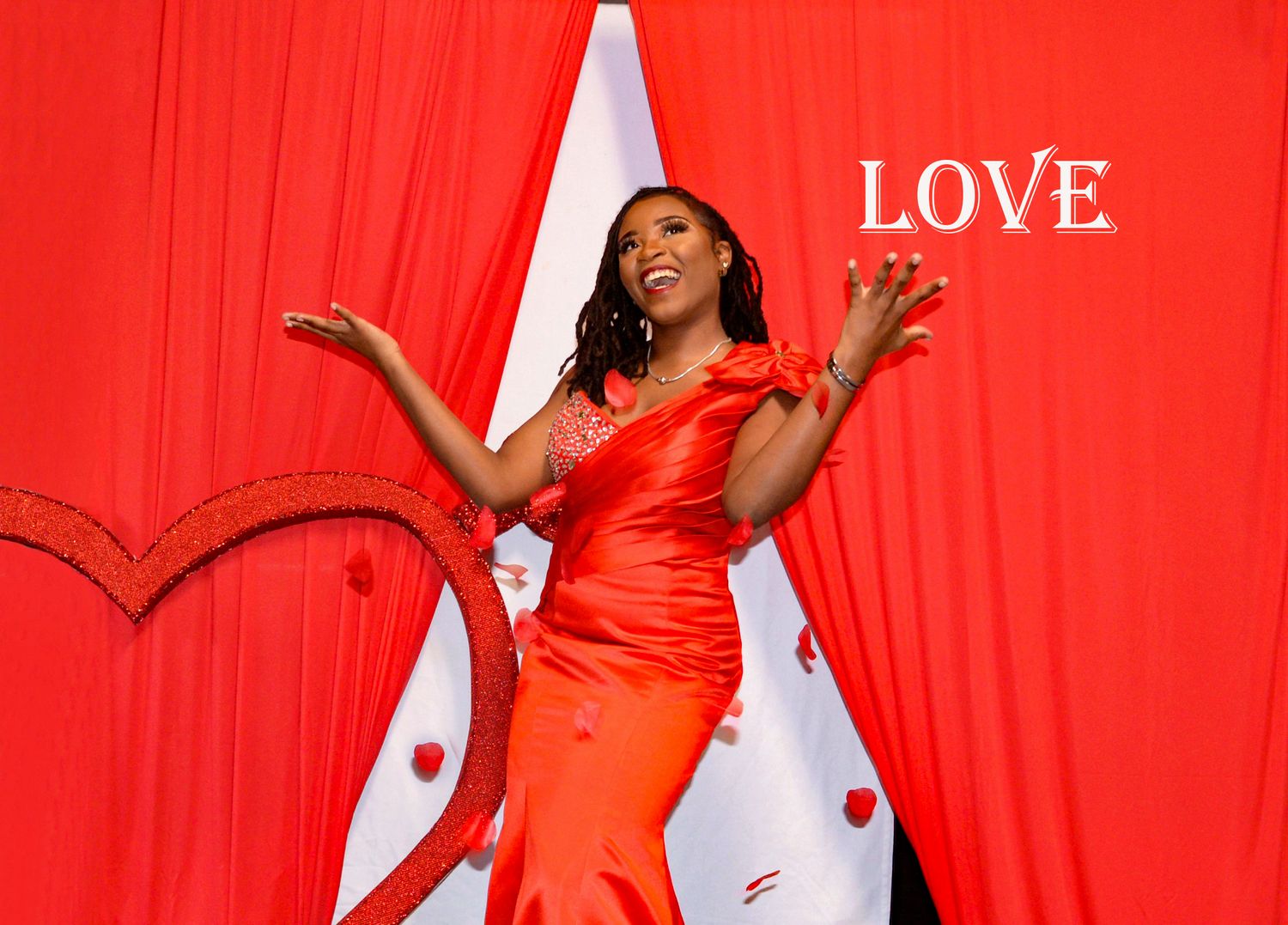 A festive scene with a red dress against a vibrant red and white heart backdrop.