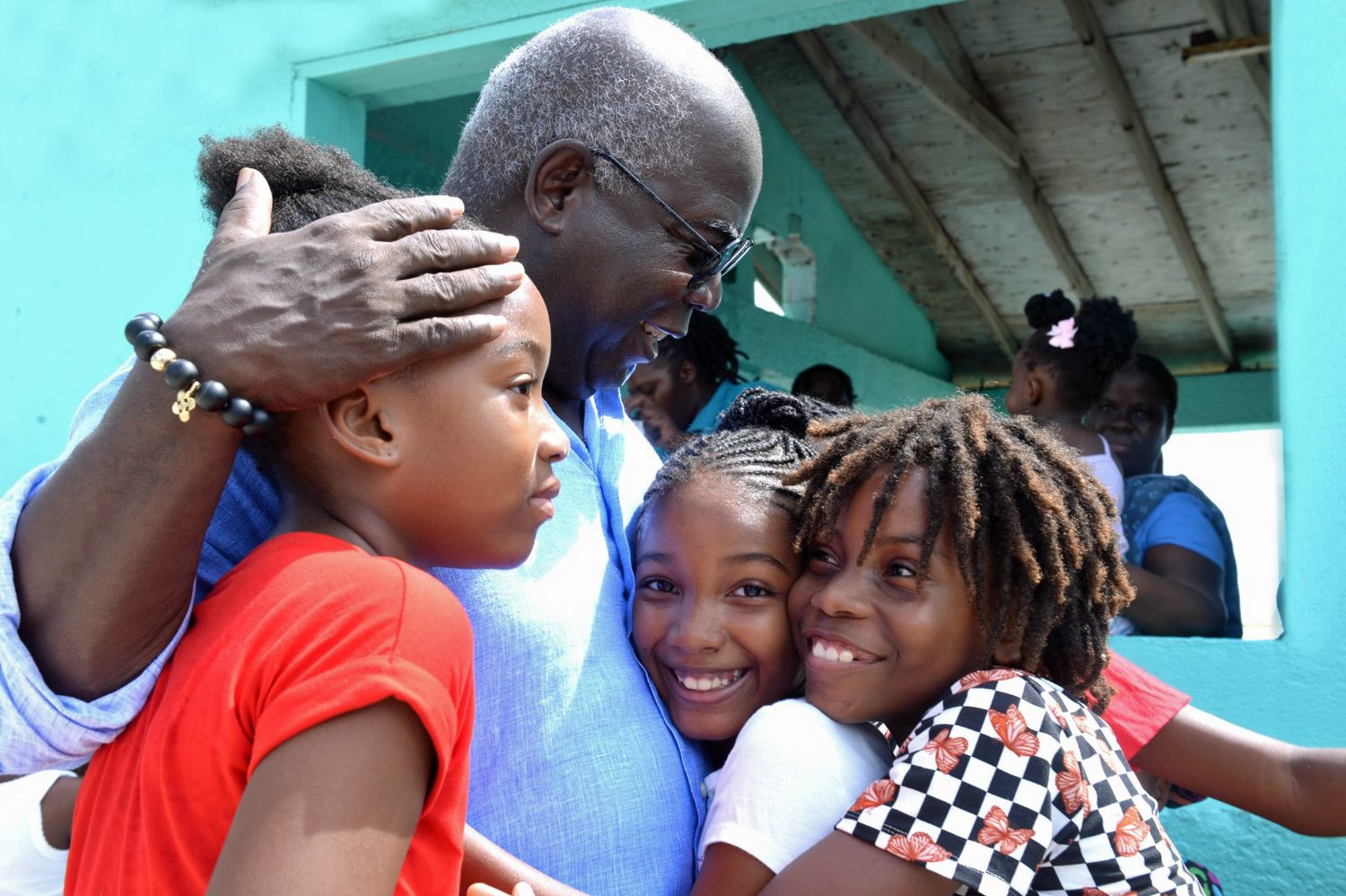 People share a joyful moment together as they embrace and smile at a community gathering.