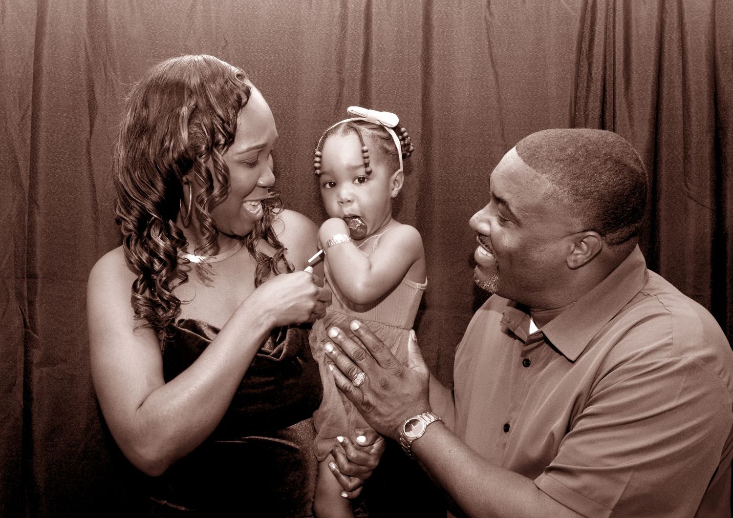 Sepia-toned family portrait showing intimate moment of joy and connection.