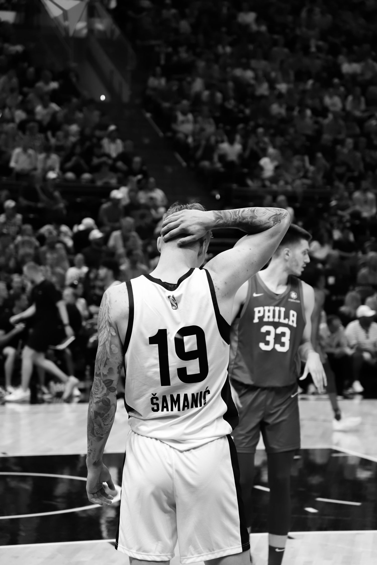 San Antonio Spurs player Samanic #19 holding his head in a black and white NBA game photo.