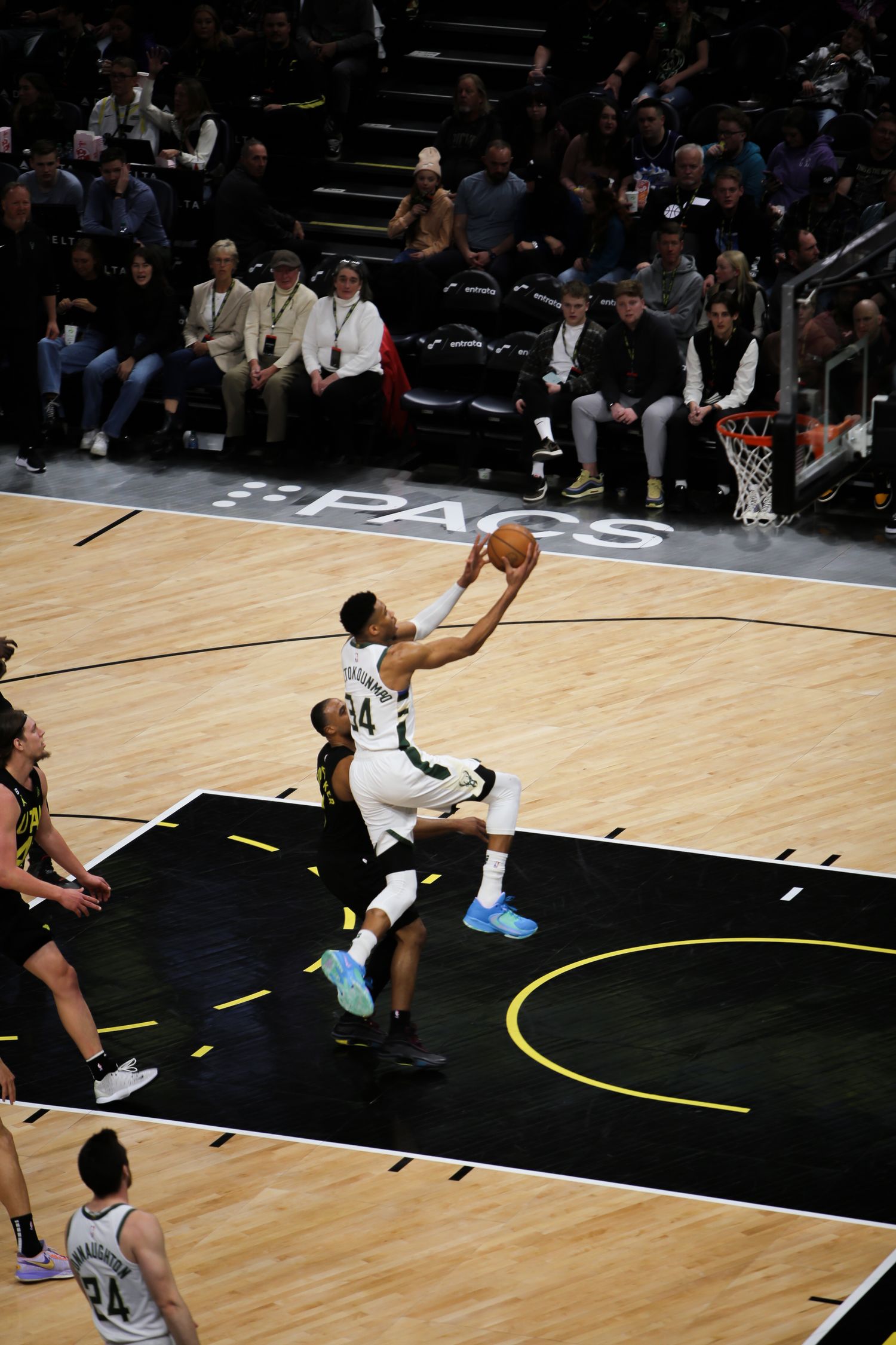 Milwaukee Bucks player #34 driving to the basket for a layup during an NBA game.