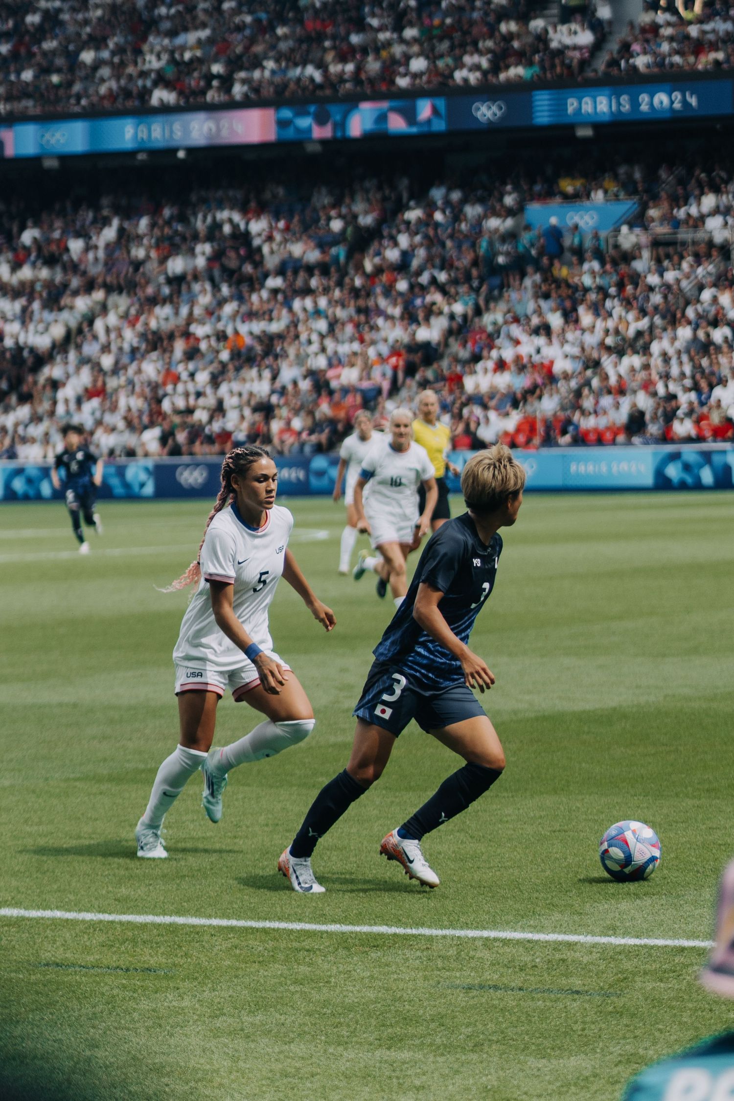 Women soccer players compete on the field during the Paris 2024 Olympic Games.