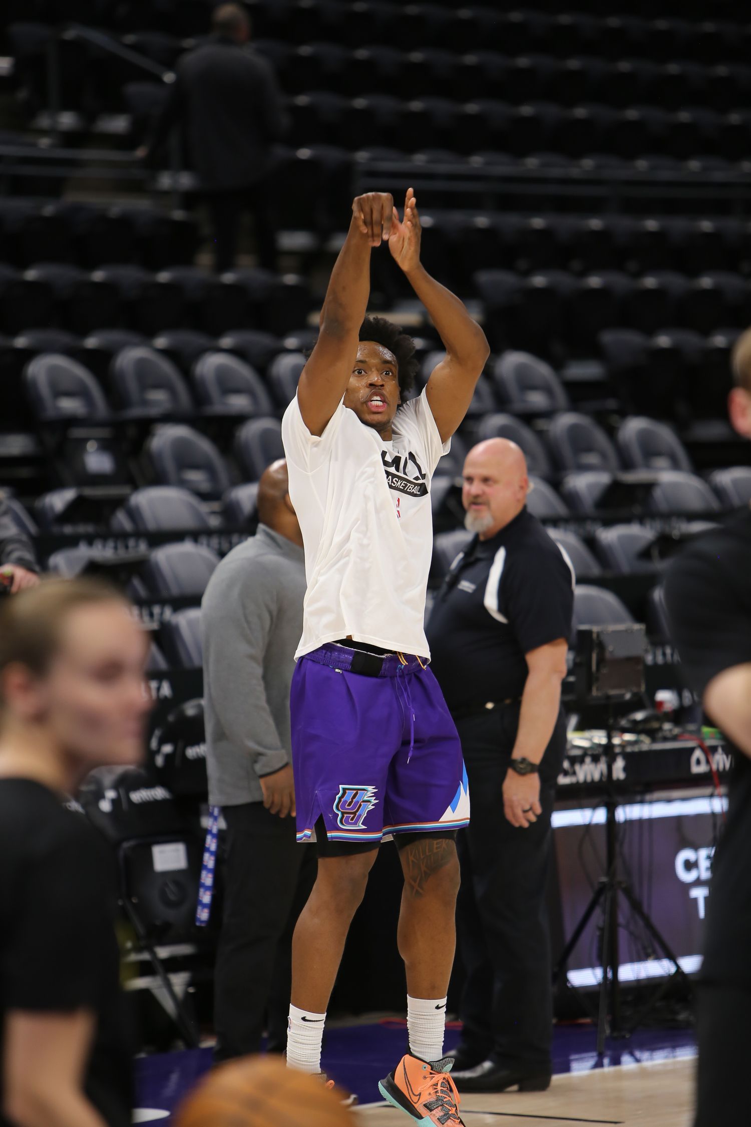 Utah Jazz player practicing jump shots during NBA pregame warmups at Delta Center.