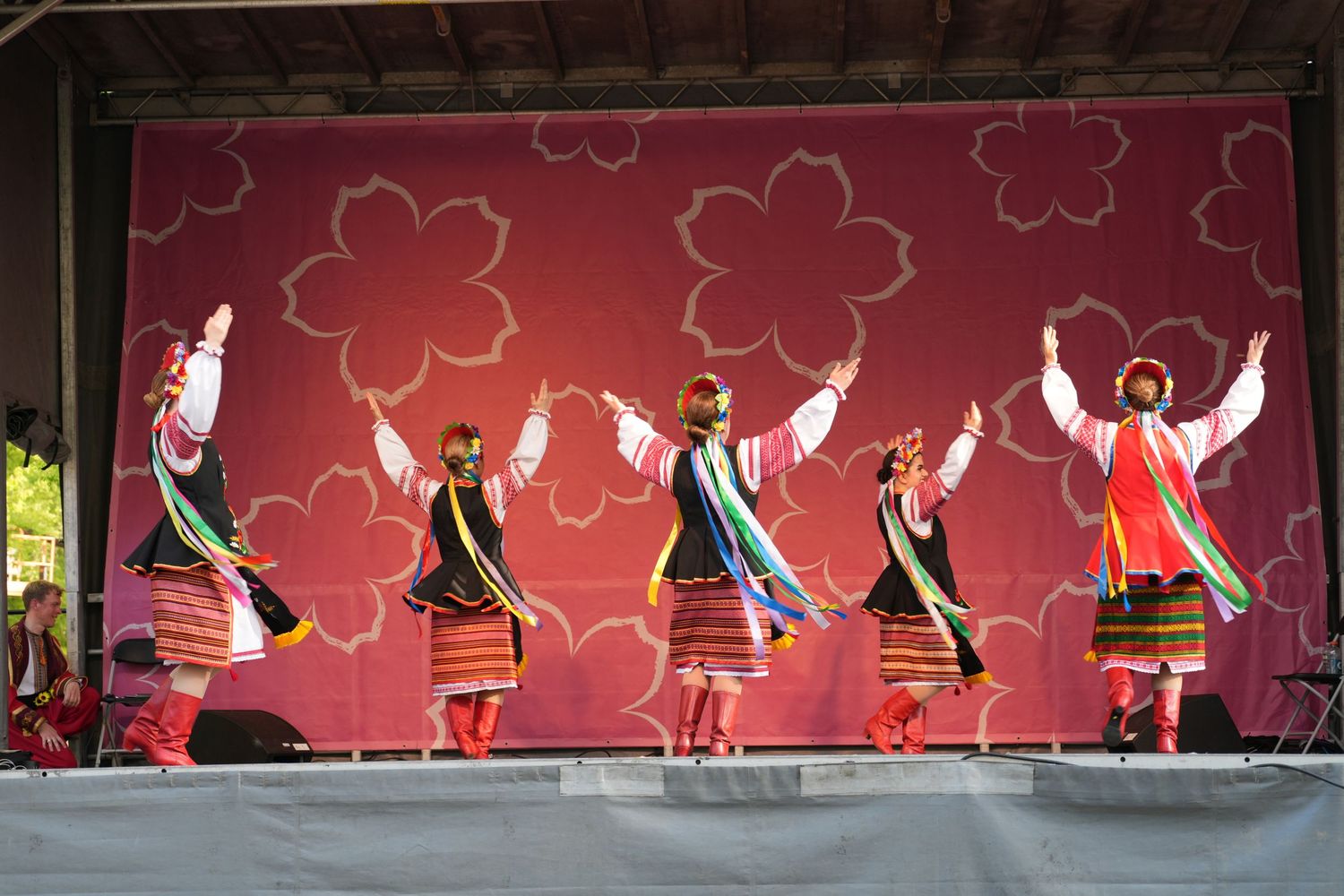 Traditional dancers performing in folk costumes on stage at a cultural festival.