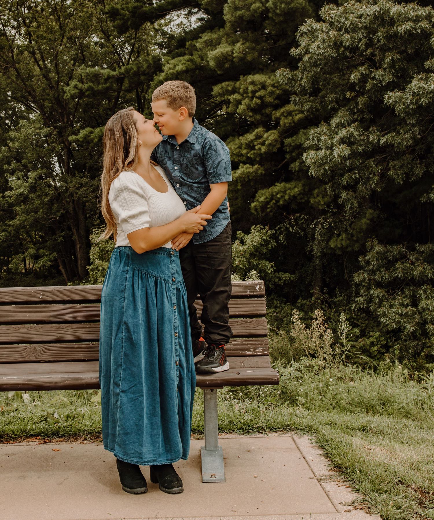 Romantic couple shares tender moments on a wooden bench in a lush garden setting across multiple poses.