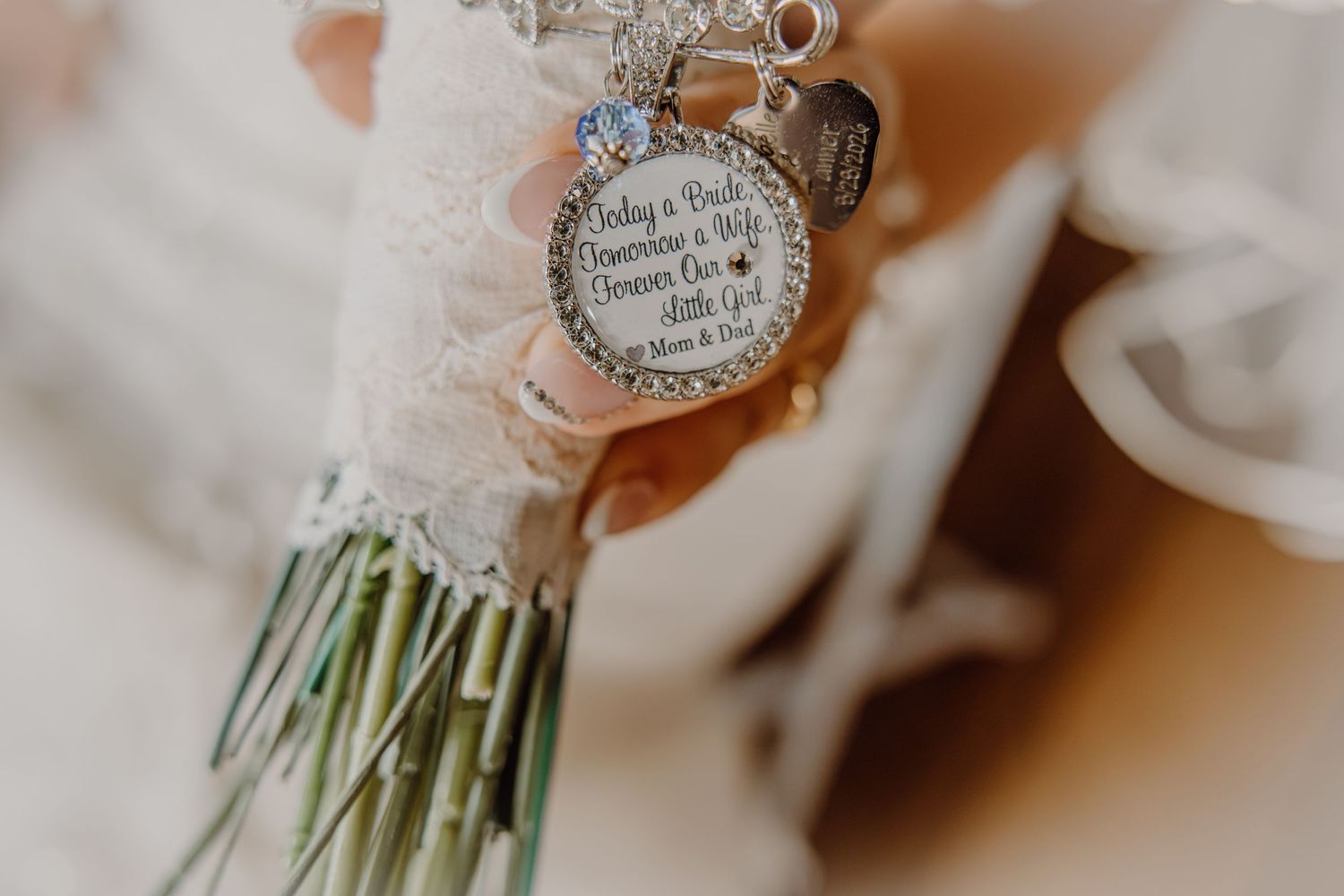 Bridal bouquet charm with sentimental memorial pendant and heart charms wrapped in white lace ribbon.