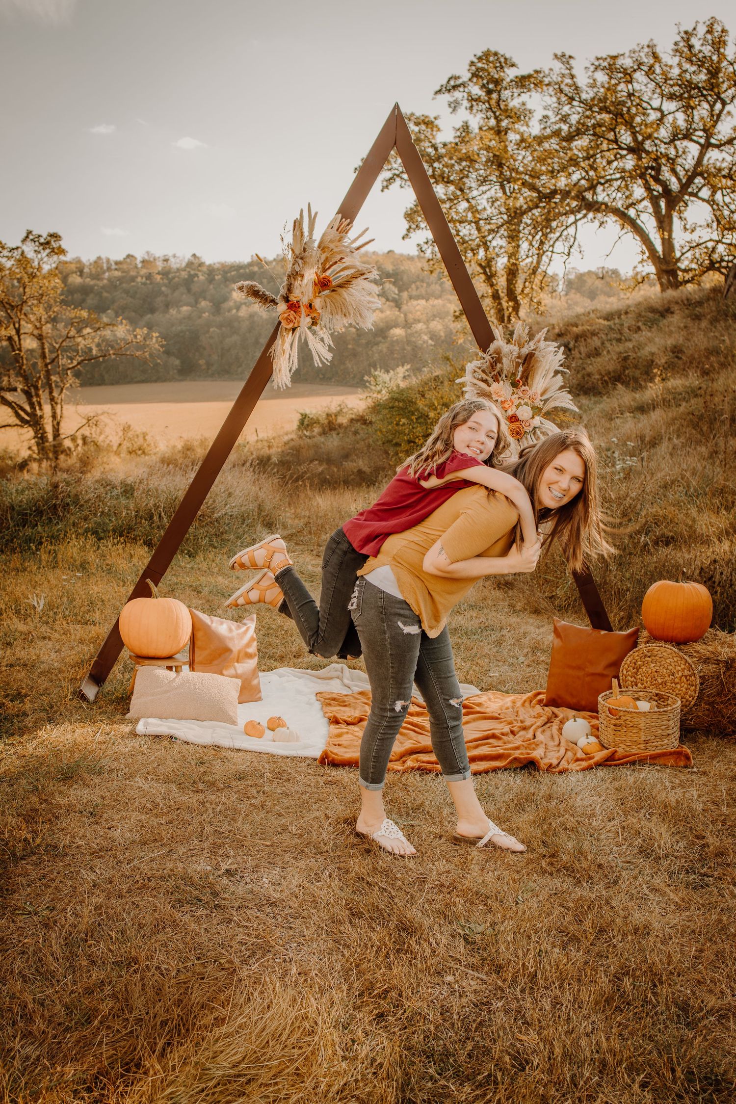 Autumn picnic scene with pumpkins, blankets and warm lighting in a golden field at sunset.