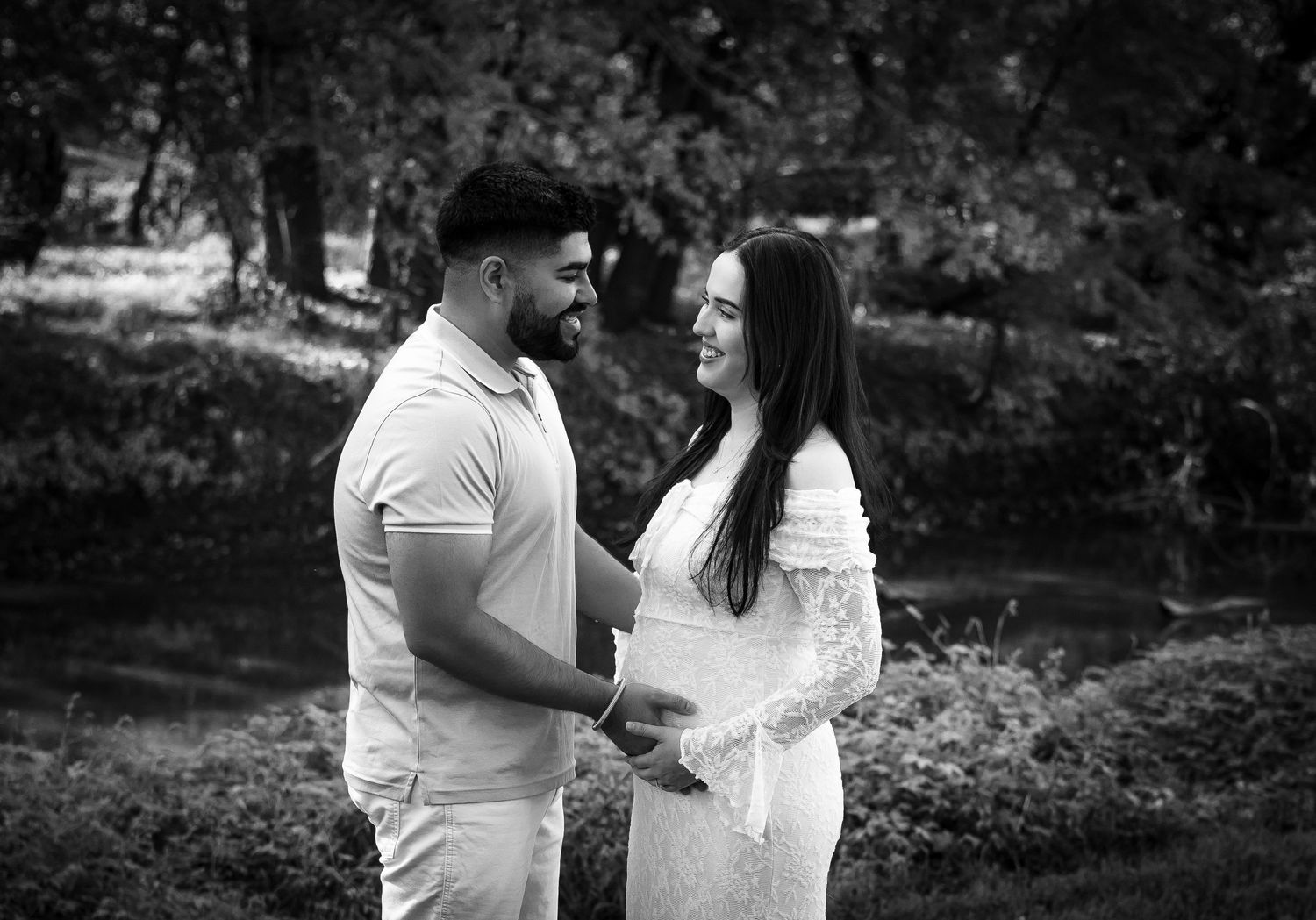 A romantic black and white photo series of a couple embracing in a lush garden setting.