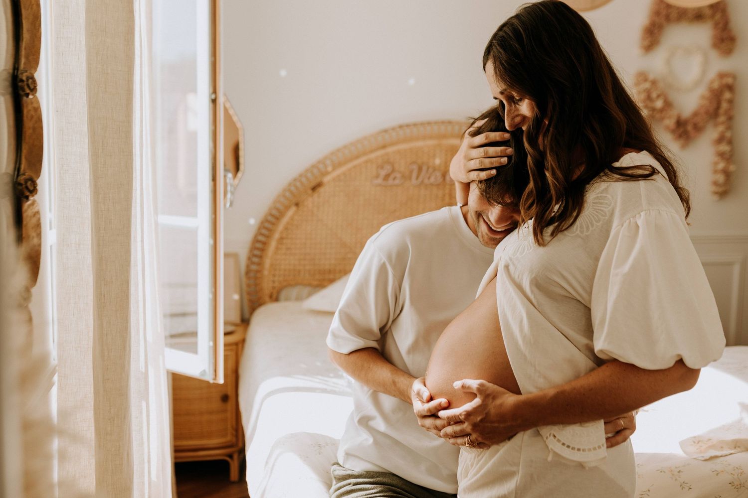 Couple attendant un enfant lors d’une séance grossesse intimiste à domicile, photographie naturelle et lumineuse à Lille